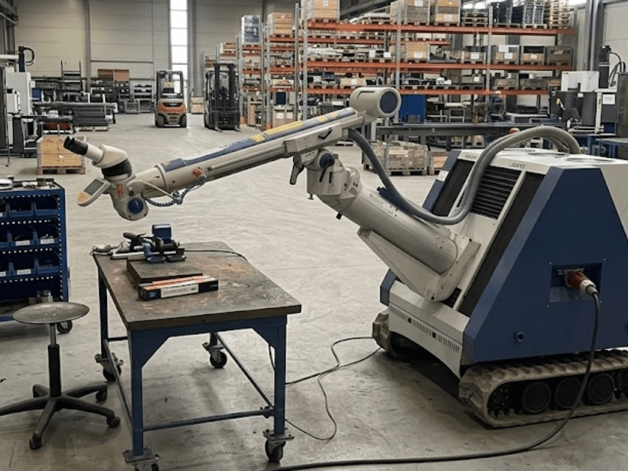 ALPHA LASER ALFlak300 M machine tool in a workshop with robotic arm, front view showcasing precision setup on worktable.