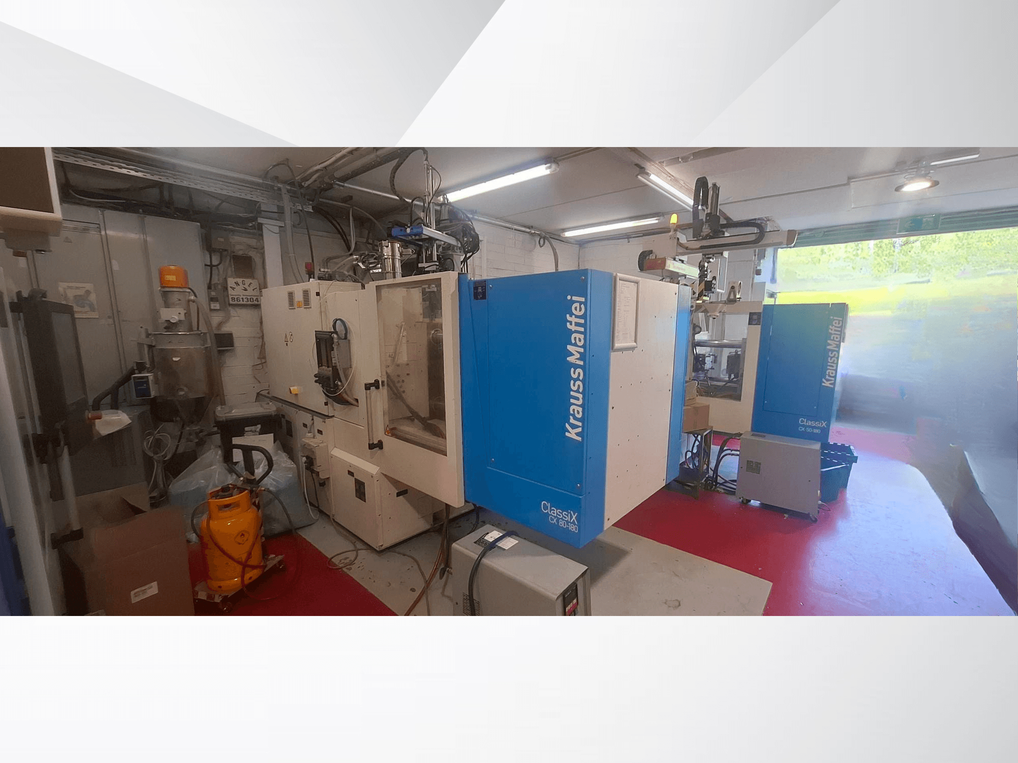 Krauss Maffei CX 80-180 hydraulic injection moulding machine, front view, in industrial setting with equipment surrounding it.