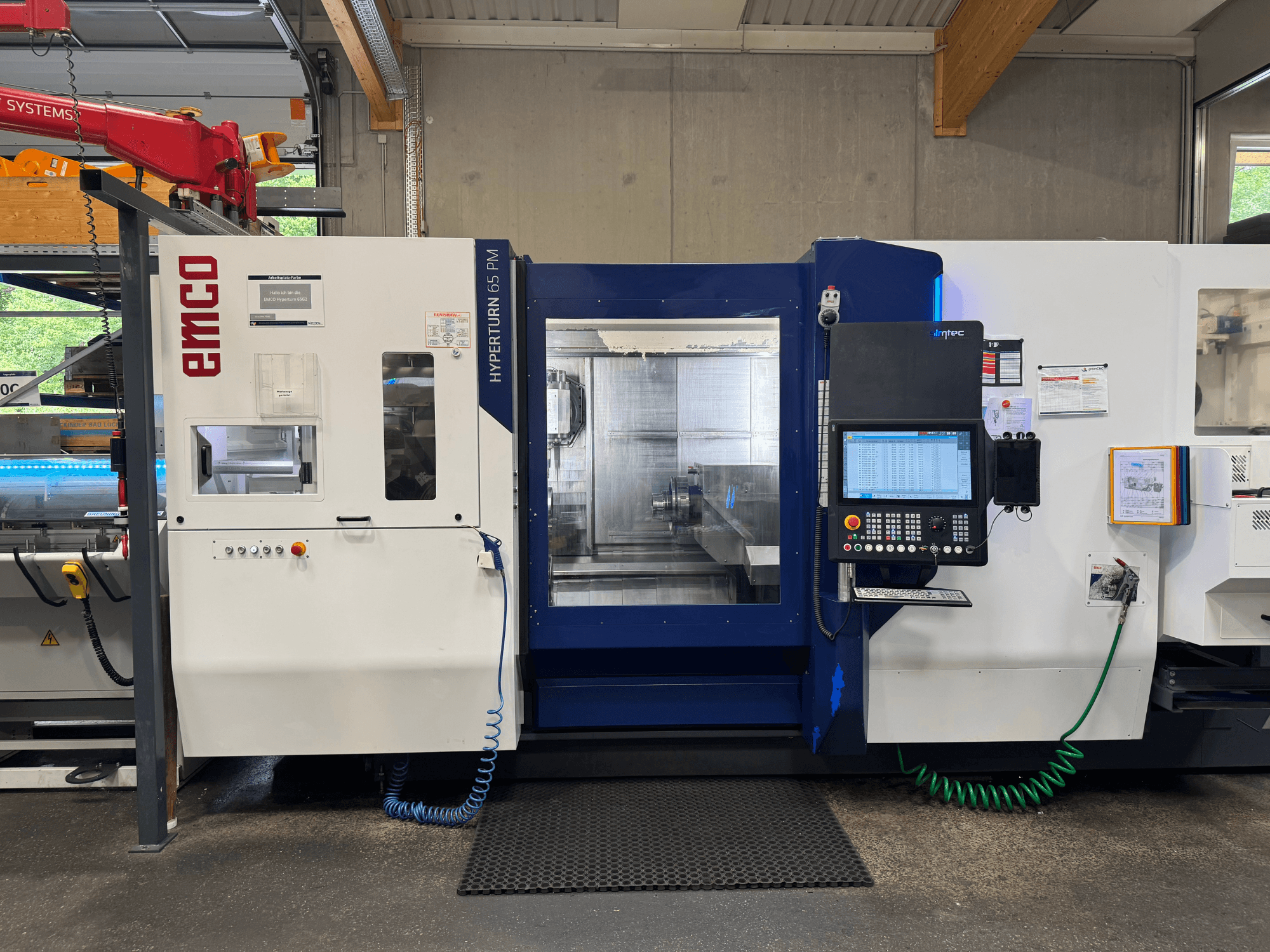EMCO Hyperturn 65 PM machine, front view, displaying control panel, spindle area, and operational features.