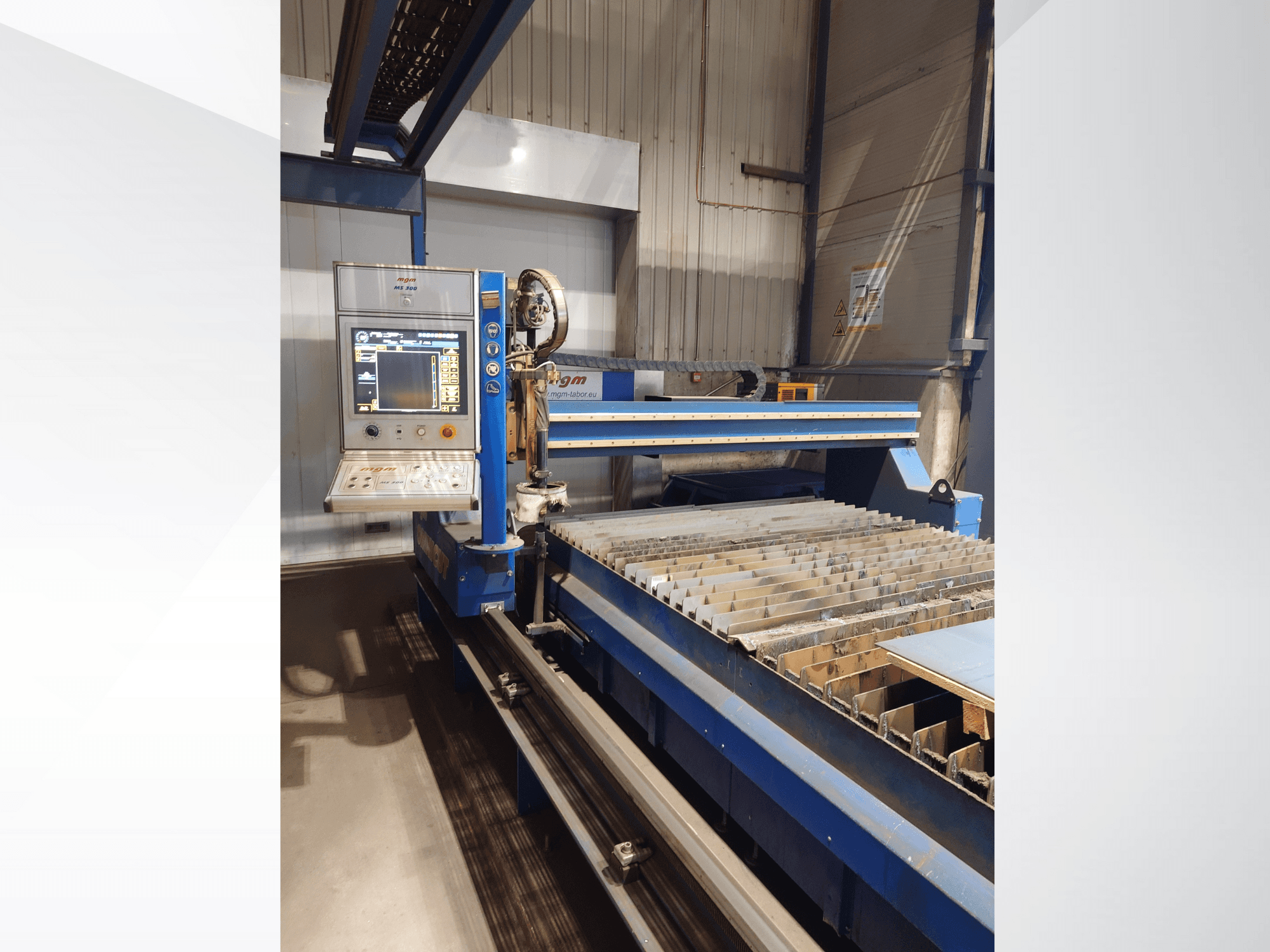CNC cutting machine by PlasmaCam, front view showing control panel and metal cutting bed with slats.