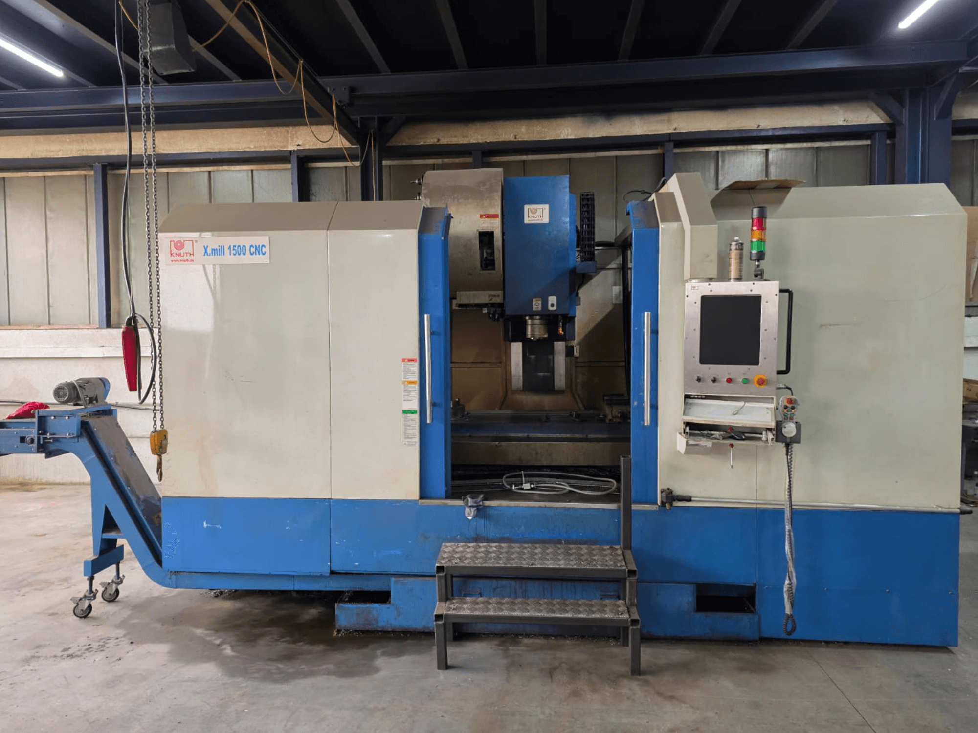 KNUTH X-MILL 1500 CNC vertical machining centre, side view, features control panel, steps, and output conveyor.