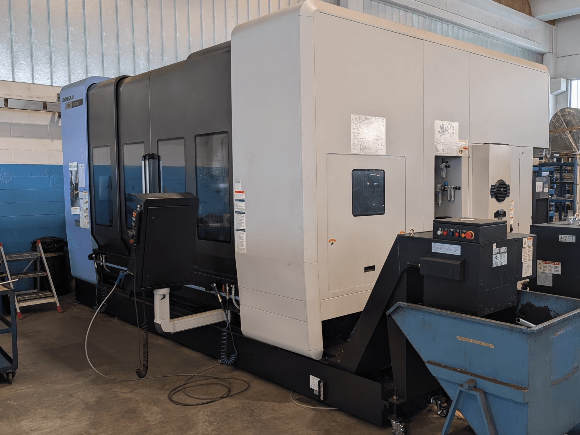 DOOSAN VCF850LSR-II vertical machining centre in side view, showcasing control panel, coolant system, and sturdy construction.