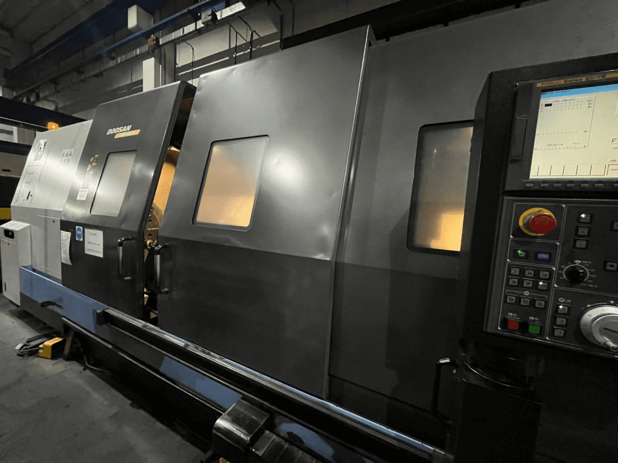 Doosan CNC lathe machine in front view, featuring control panel and operator interface with visible digital display and buttons.