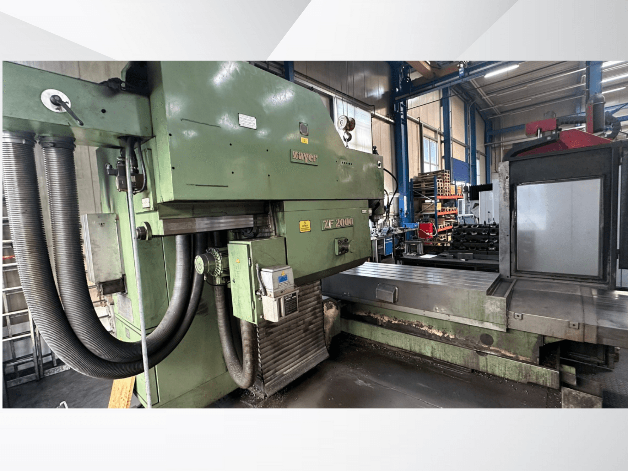Zayer ZF 2000 milling machine in green, side view showing control panel and large milling bed with attached hoses.