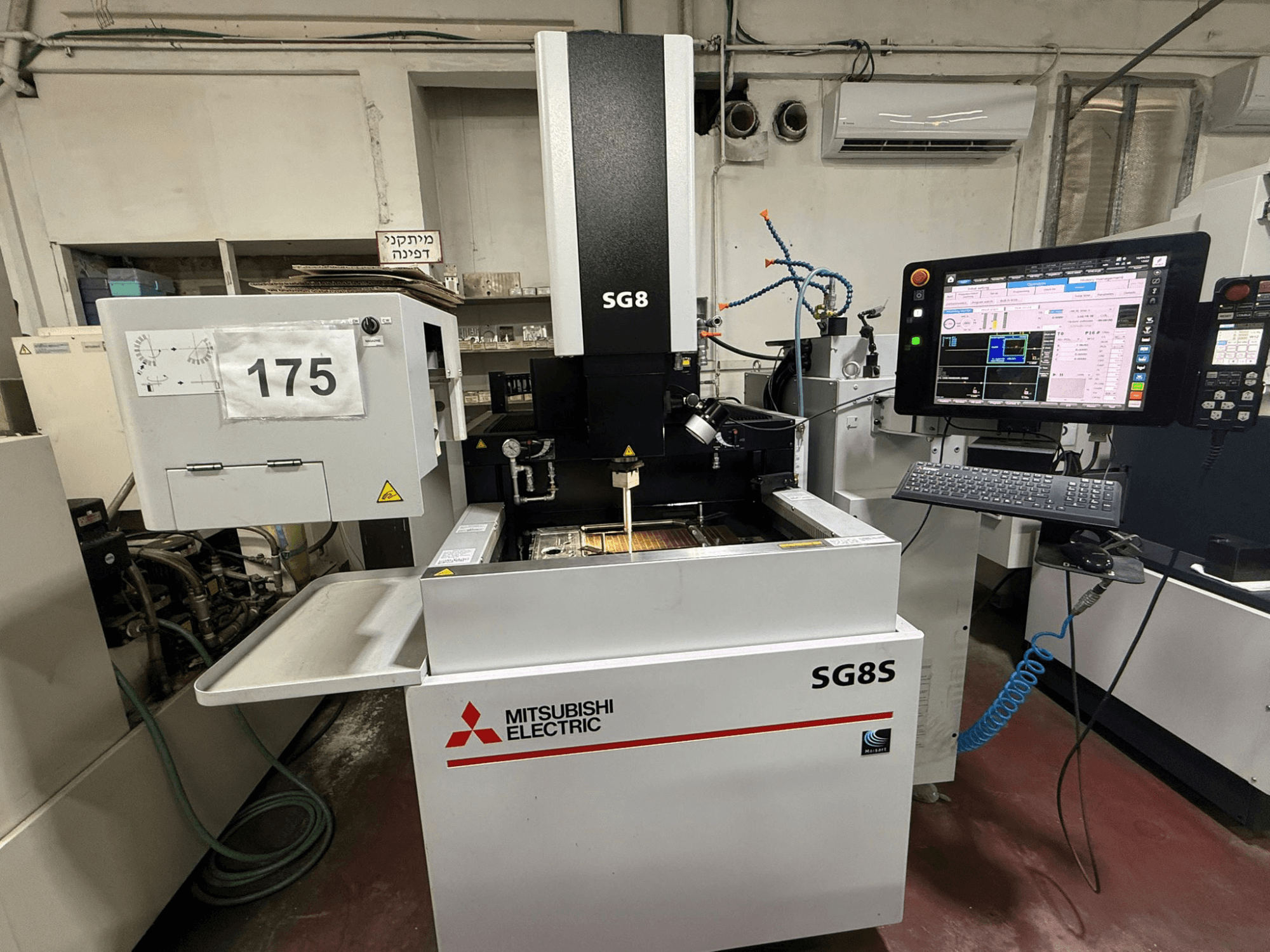 Mitsubishi SG8S die-sinking EDM machine, front view with monitor and control panel visible; working area shows tool setup.
