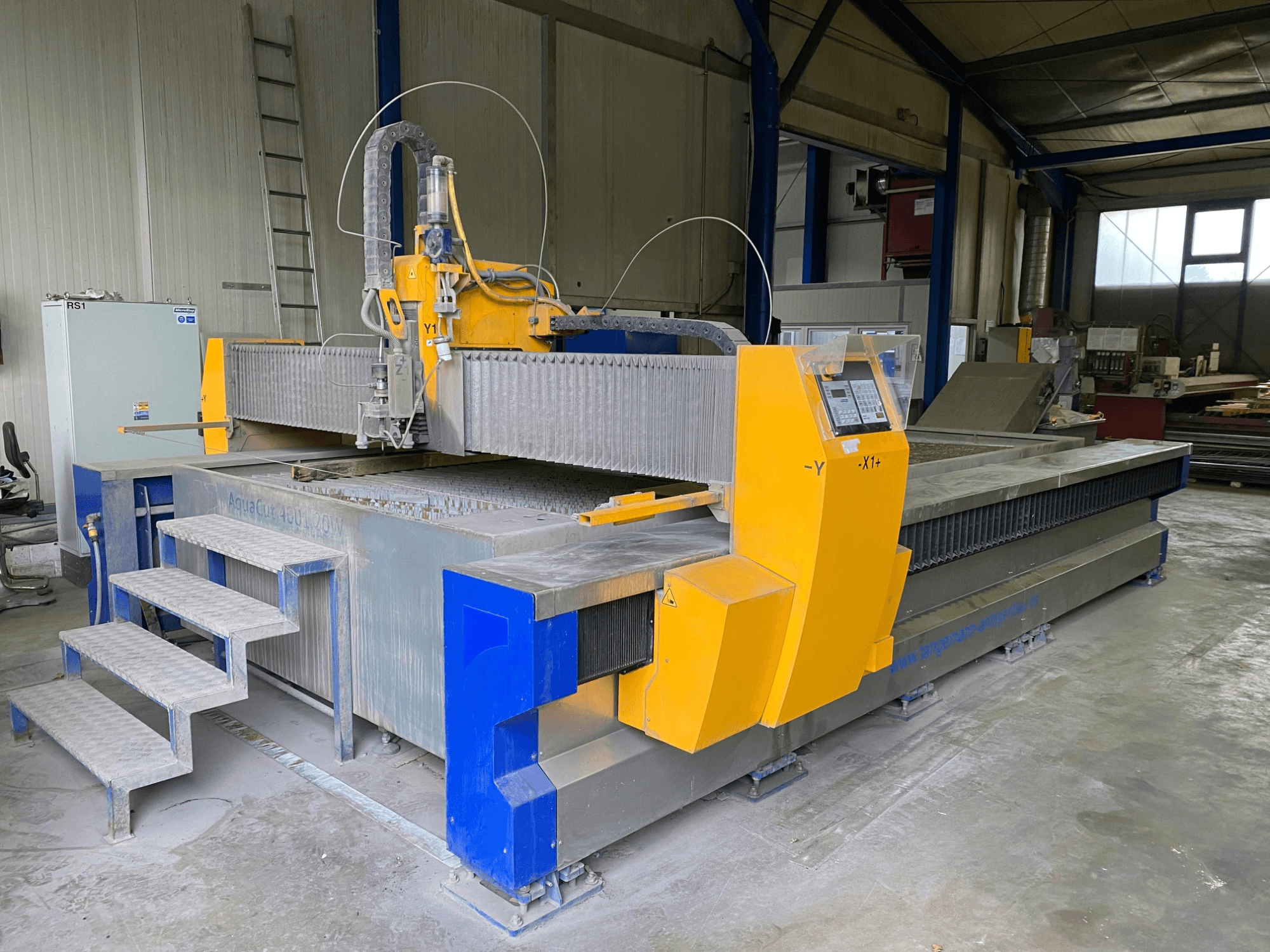 MicroStep AquaCut-W 4001.20 waterjet cutting machine in a workshop, showcasing steps and control panel from a side view.