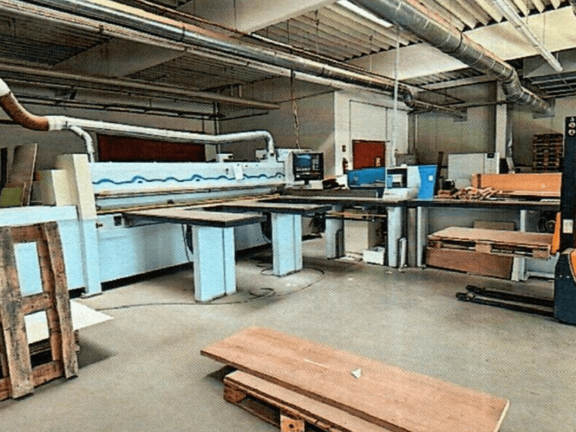 HOMAG HPL 11/38/22 panel saw in a workshop, featuring a large cutting table and display console, viewed from the front.