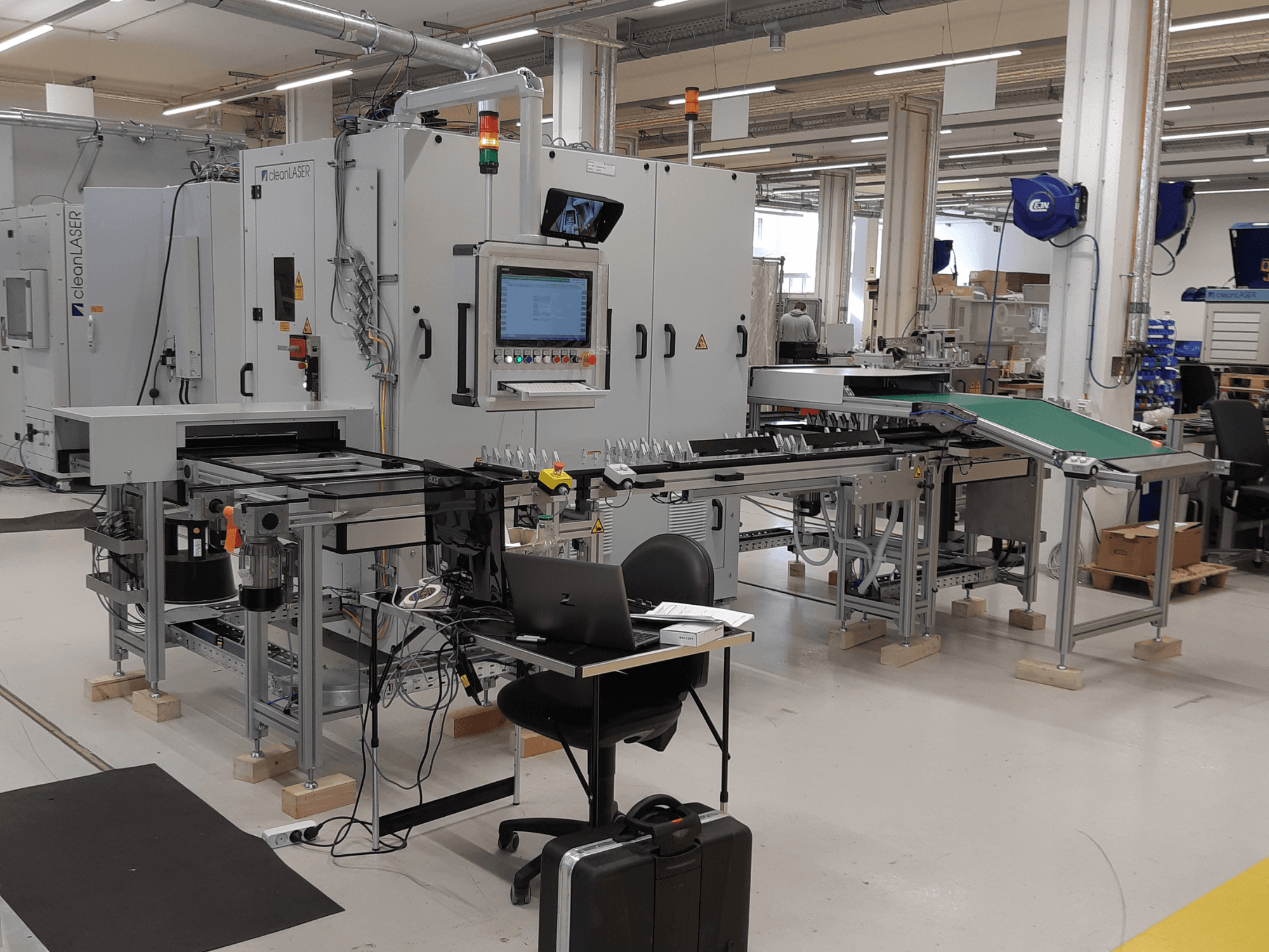 CLEAN LASER clean CELL 3220 machine tool, front view showcasing control panel, conveyor, and workspace setup in a factory environment.