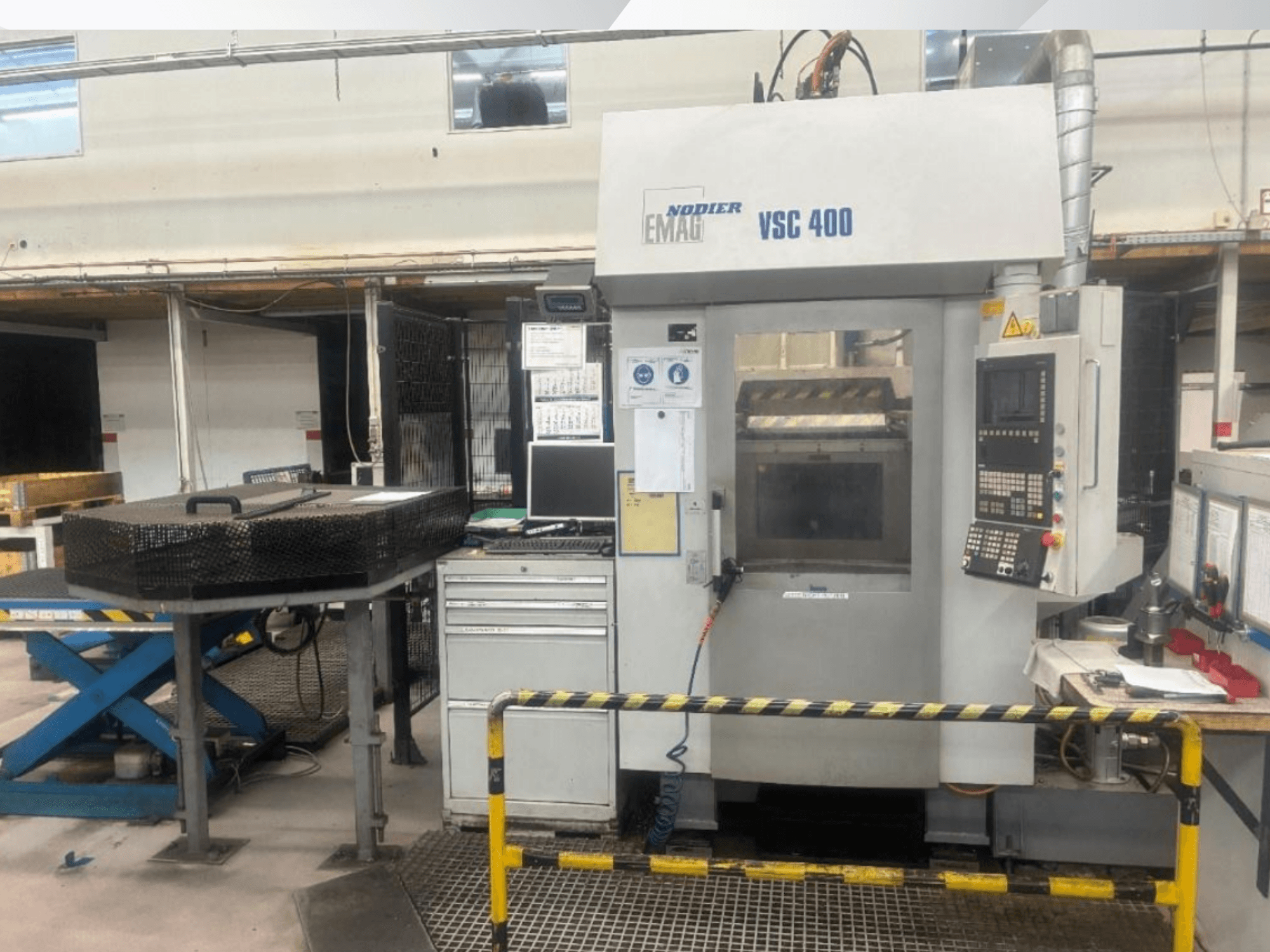 EMAG VSC 400 vertical turning machine front view, featuring control panel, safety barriers, and surrounding equipment in a well-lit workshop.