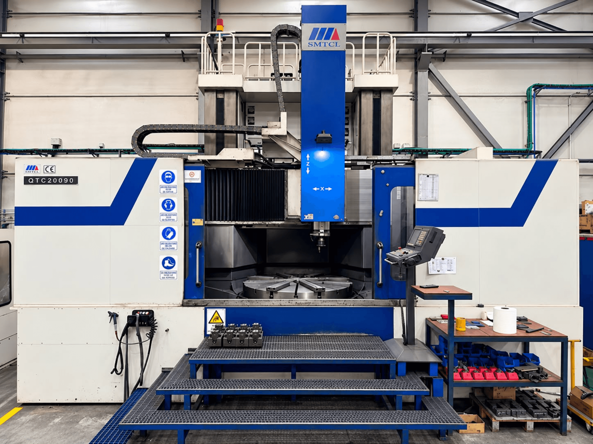 SMTCL QTC 20090 vertical turning machine in a workshop, front view, featuring control panel and worktable.