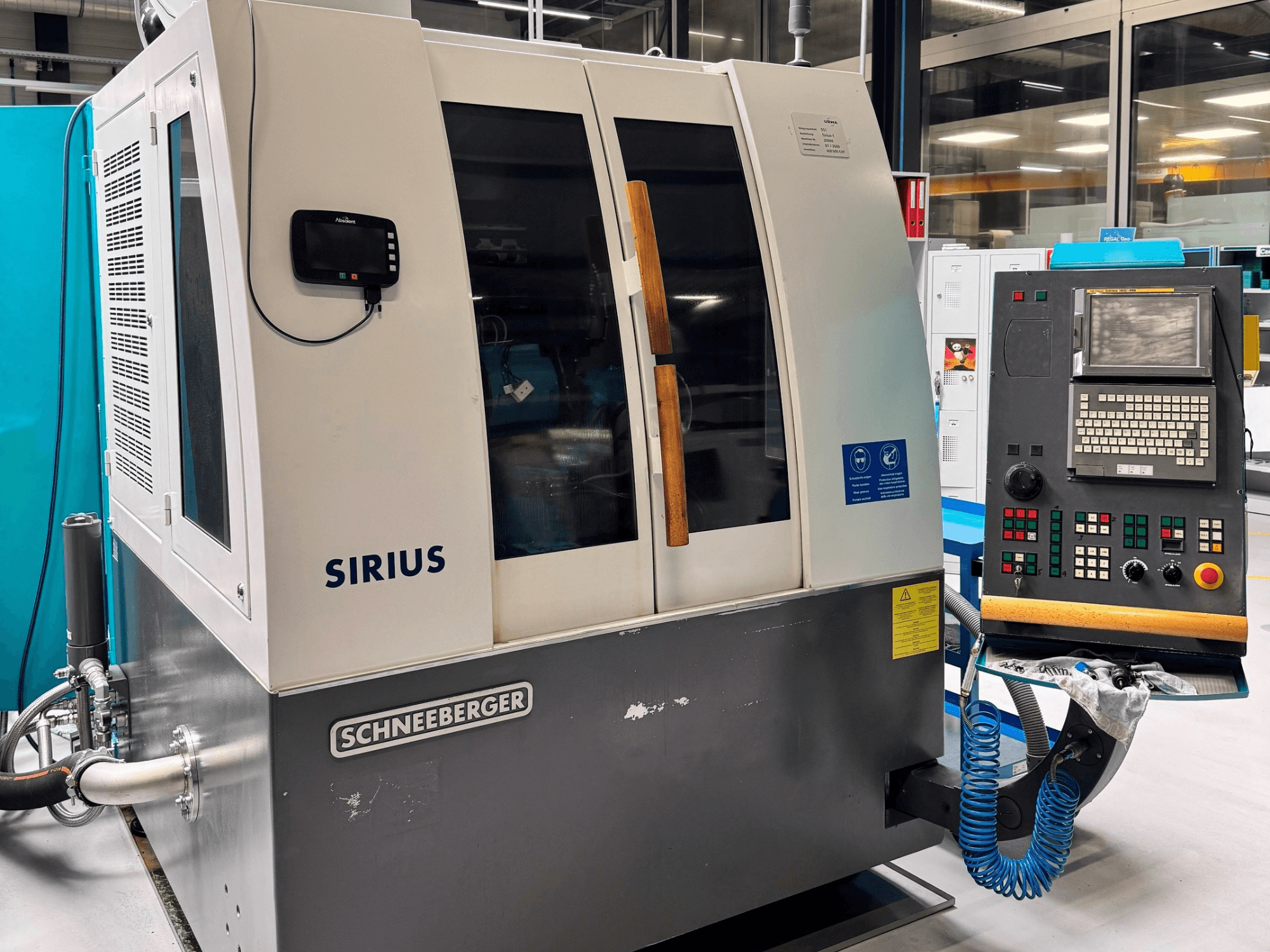Schneeberger Sirius HPM surface grinding machine, side view, showing control panel and operational indicators.