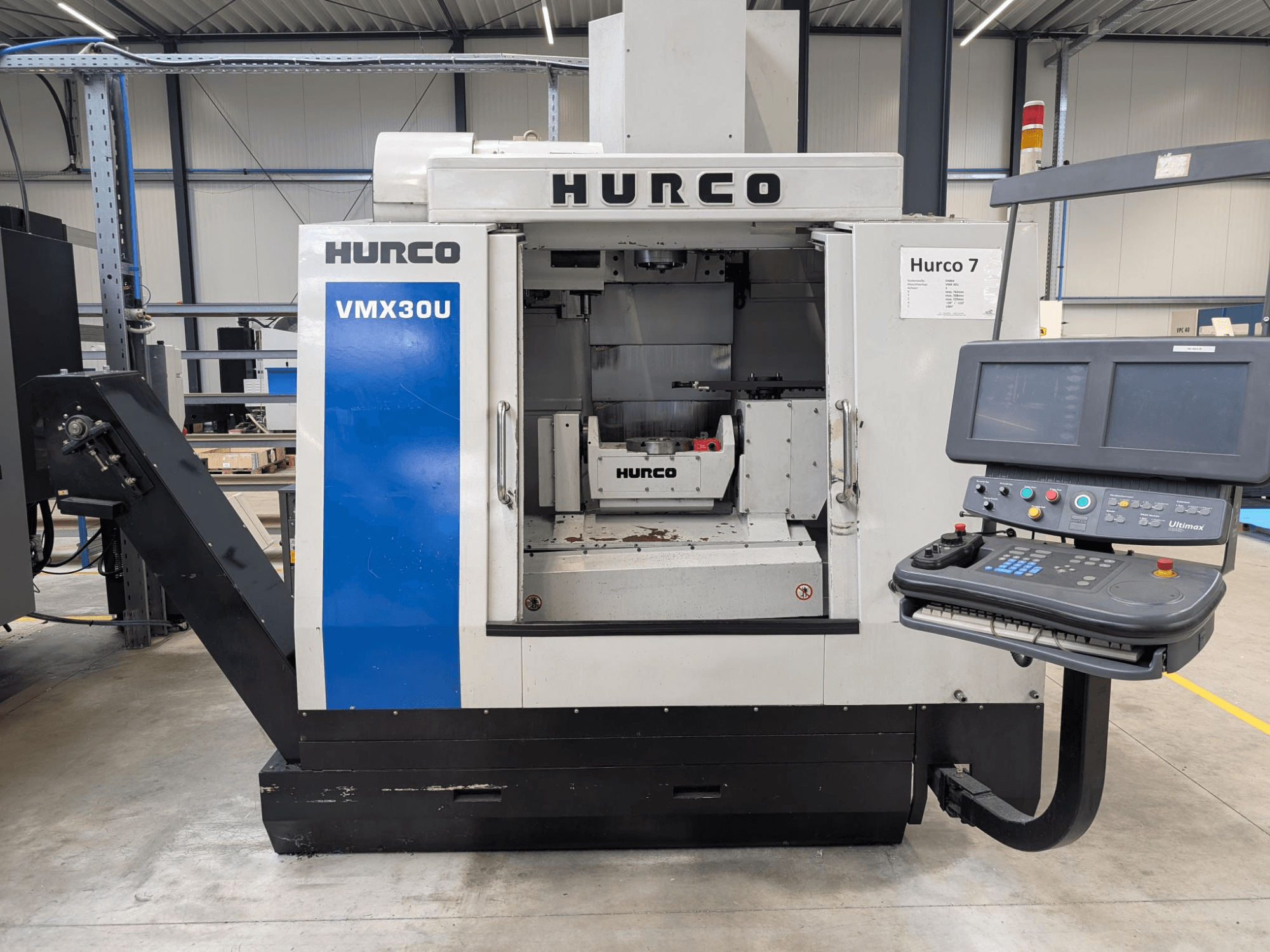 Hurco VMX30U CNC machine in front view with control panel; features a spacious interior and precision control interface.
