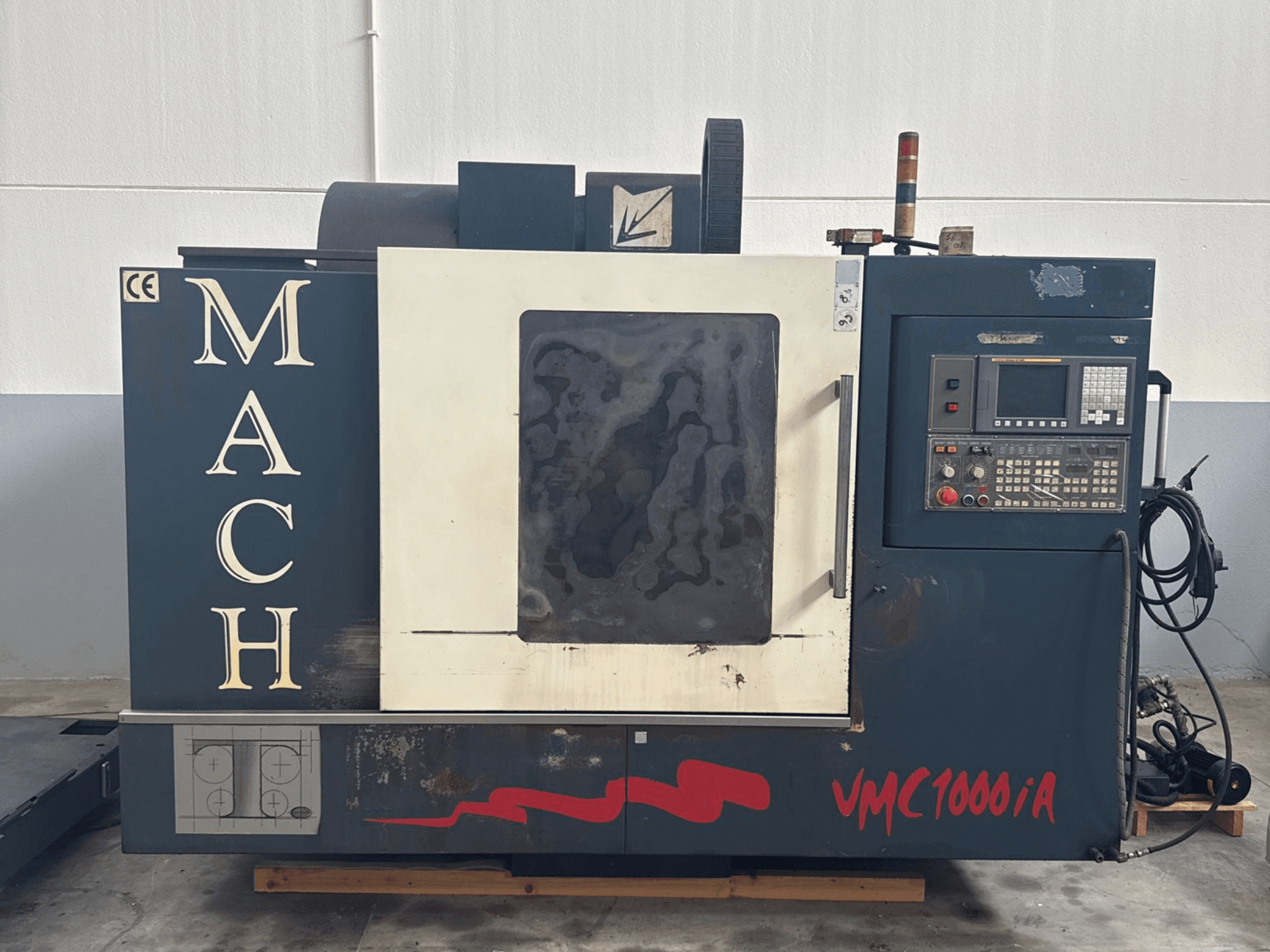 Vertical machining center MIND MACH VMC 1000/A in front view, featuring control panel, spindle, and base markings.