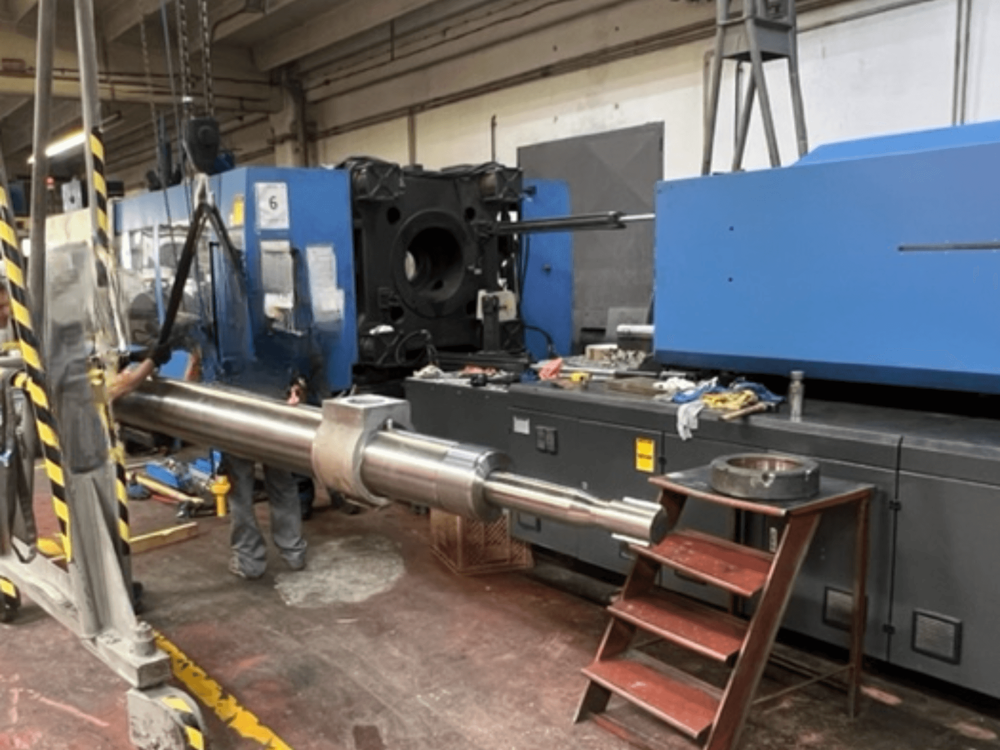 Hydraulic Injection Moulding Machine HAITIAN SA8000, shown in a side view with a large hydraulic rod being hoisted.