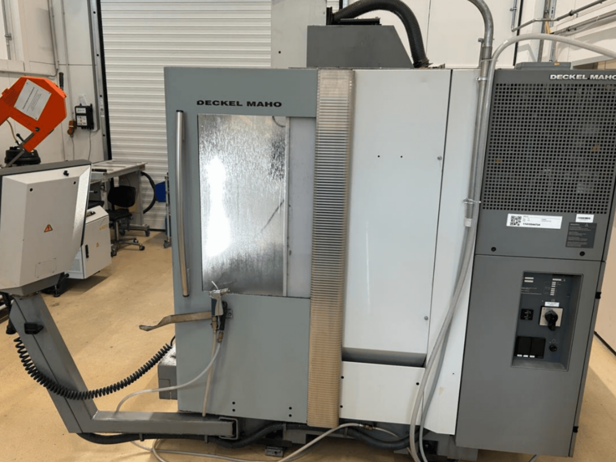 DECKEL MAHO DMU 50 vertical machining centre front view, showing controls, cooling system, and machining area with reflective panel.