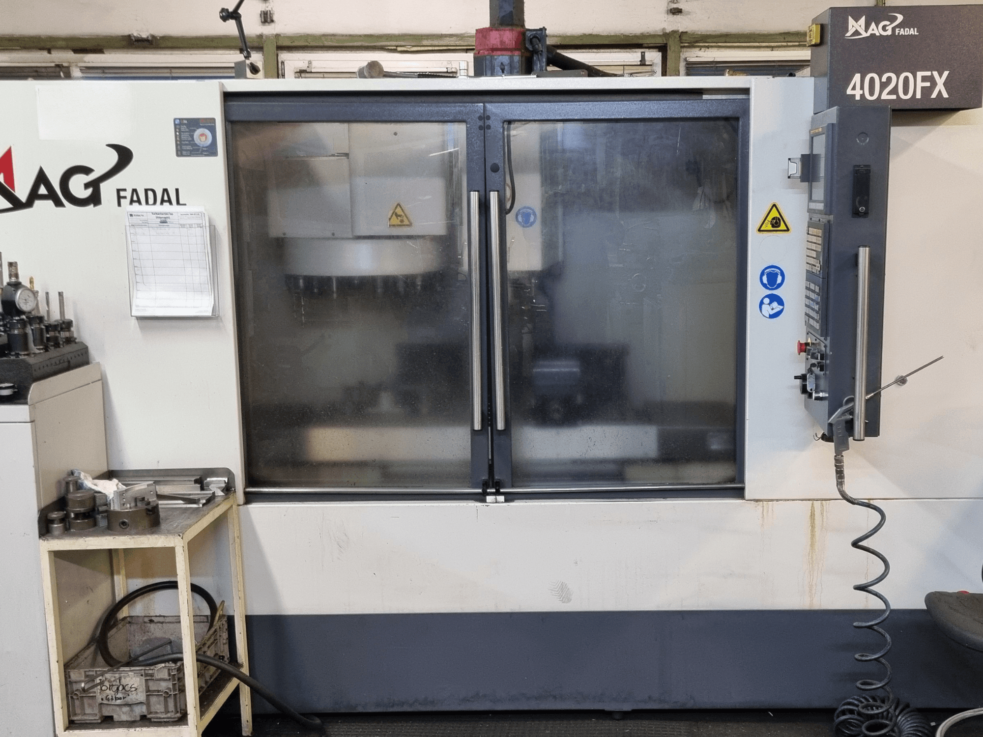 Front view of FADAL 4020 FX vertical machining center with control panel, safety warnings, and visible work area.