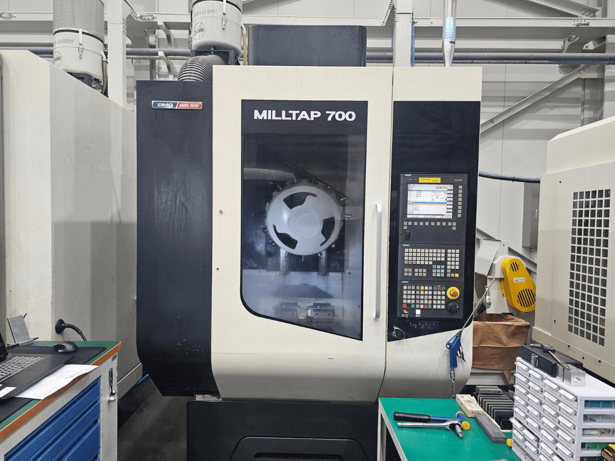 DMG MORI MILLTAP 700 vertical machining center, front view, showcasing control panel, spindle, and workspace details.
