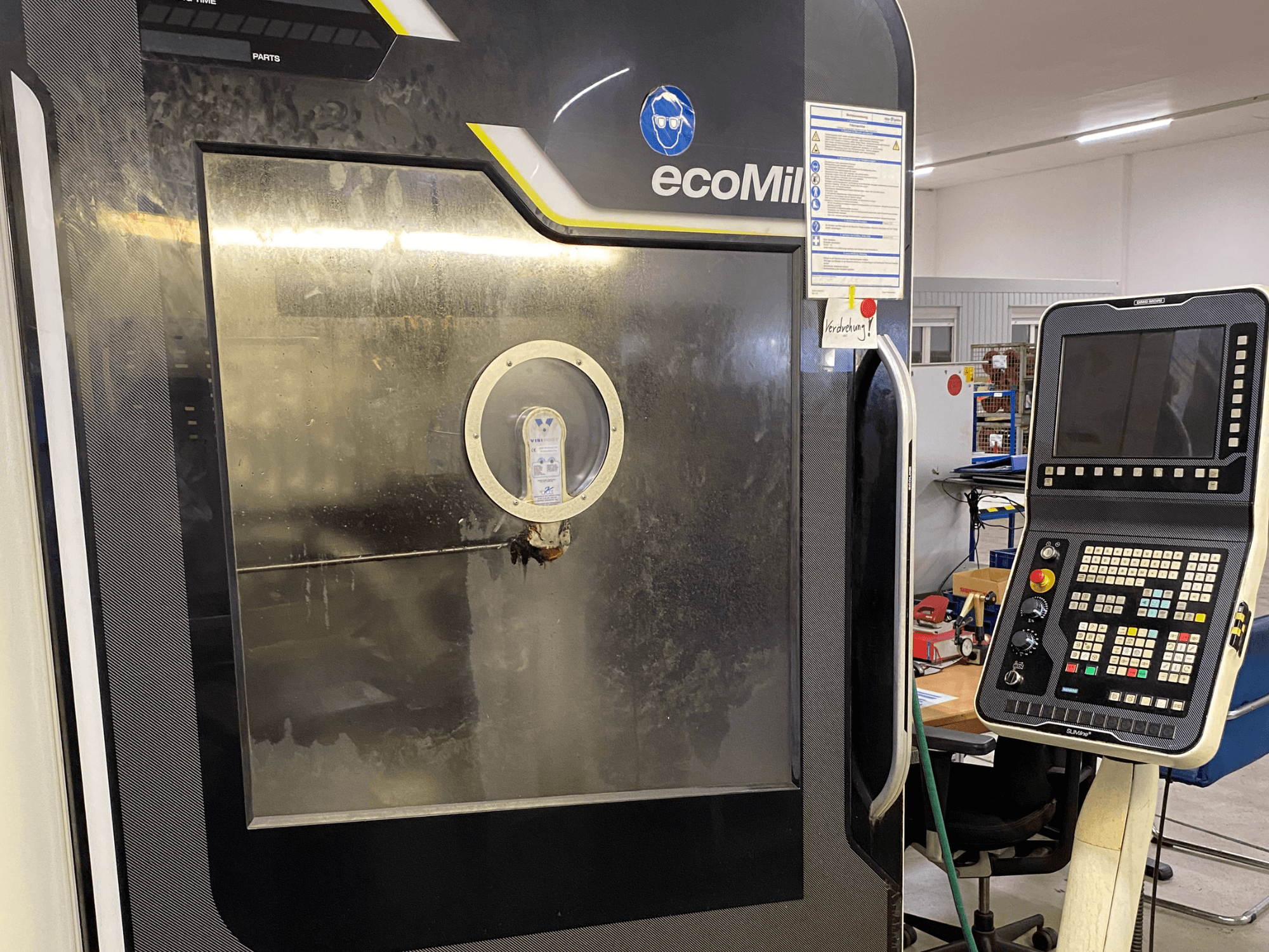 DMG MU 70 ECO Mill in front view, featuring a control panel on the right and a glass panel revealing interior components.