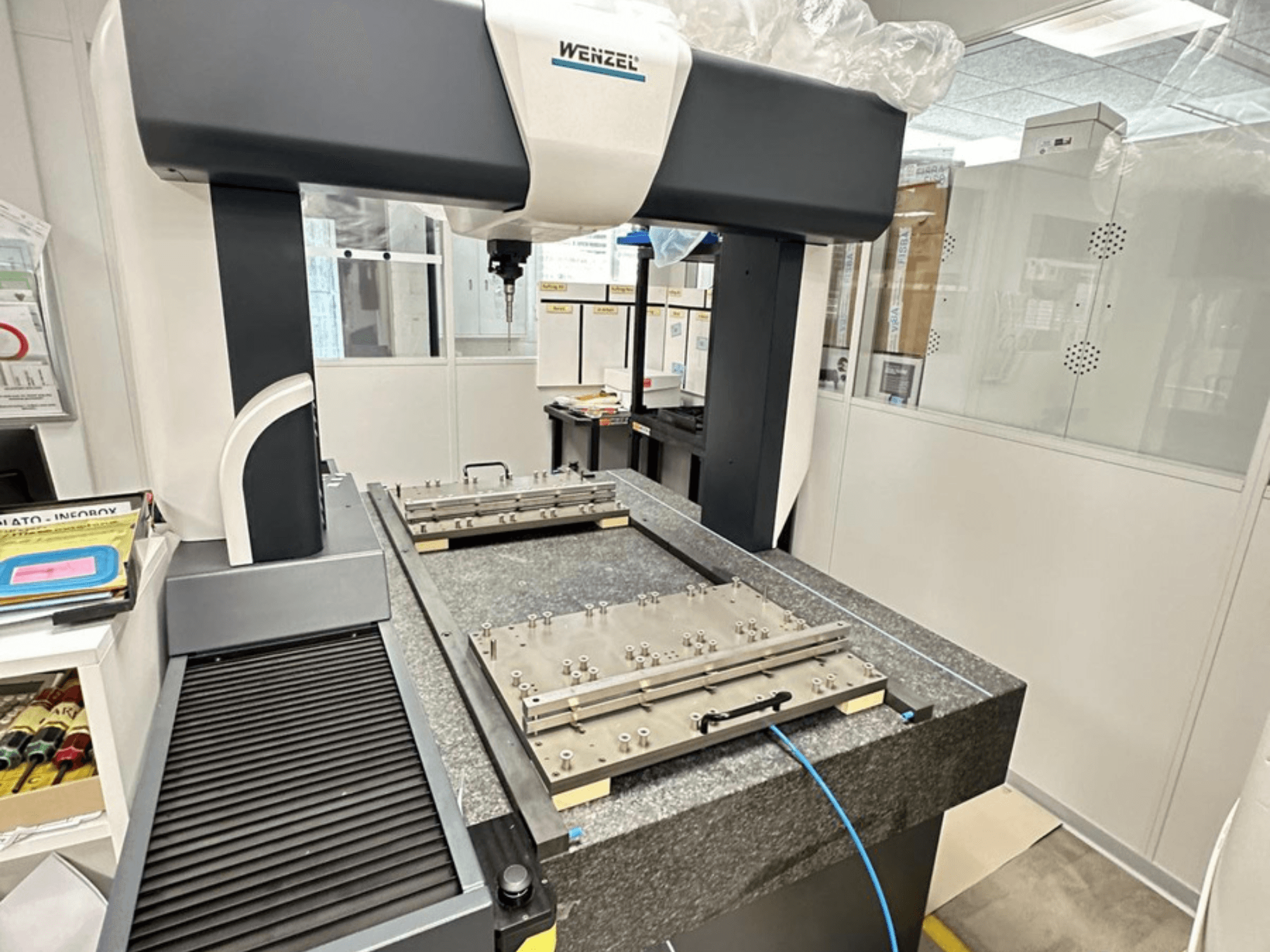 Wenzel LH 65 CMM in a laboratory setting, displaying a granite base with adjustable measuring platform and overhead arm.