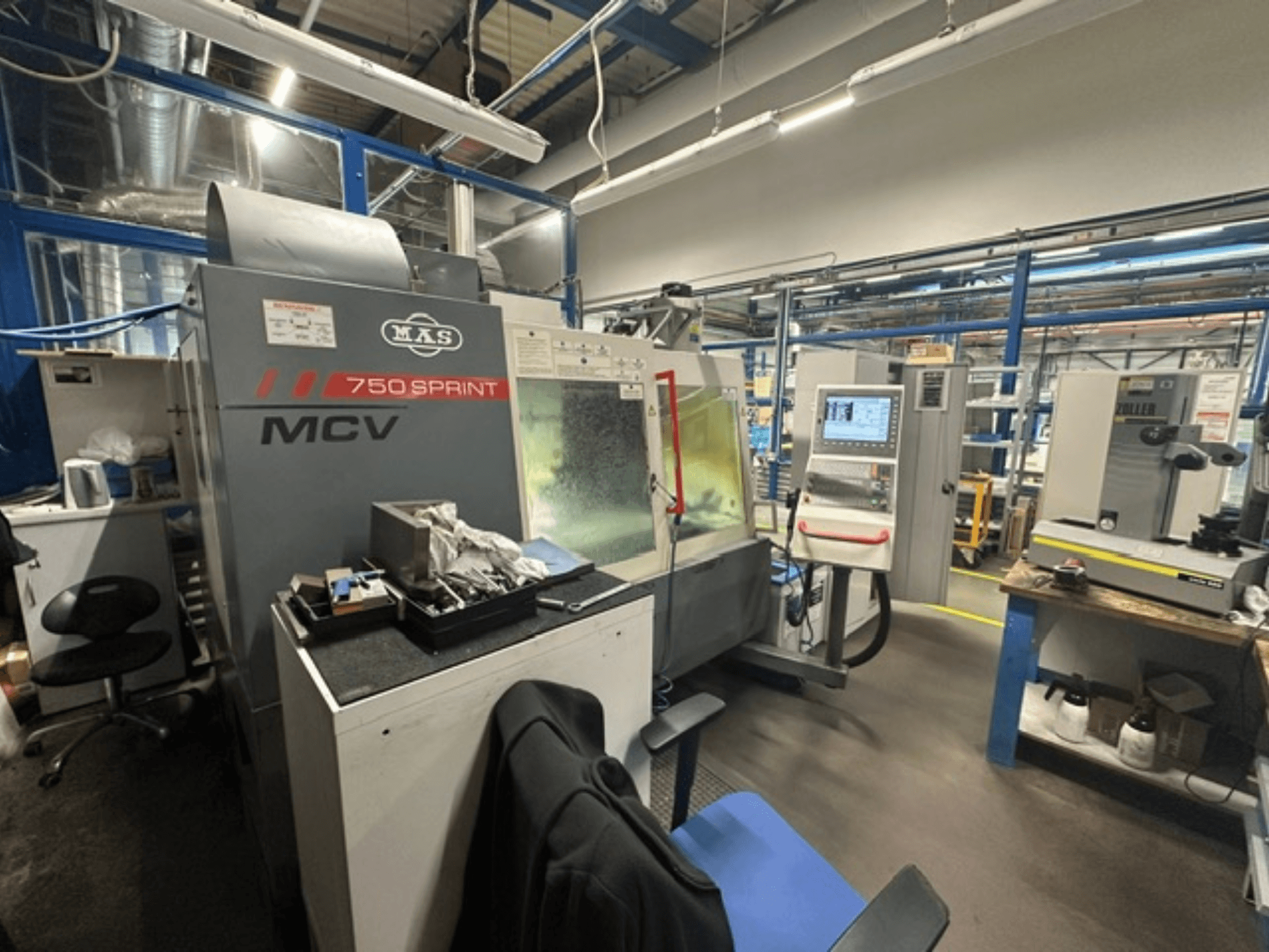 Vertical machining centre KOVOSVIT MAS MCV 750 Sprint in a workshop, showcasing control panel and work area from a side view.