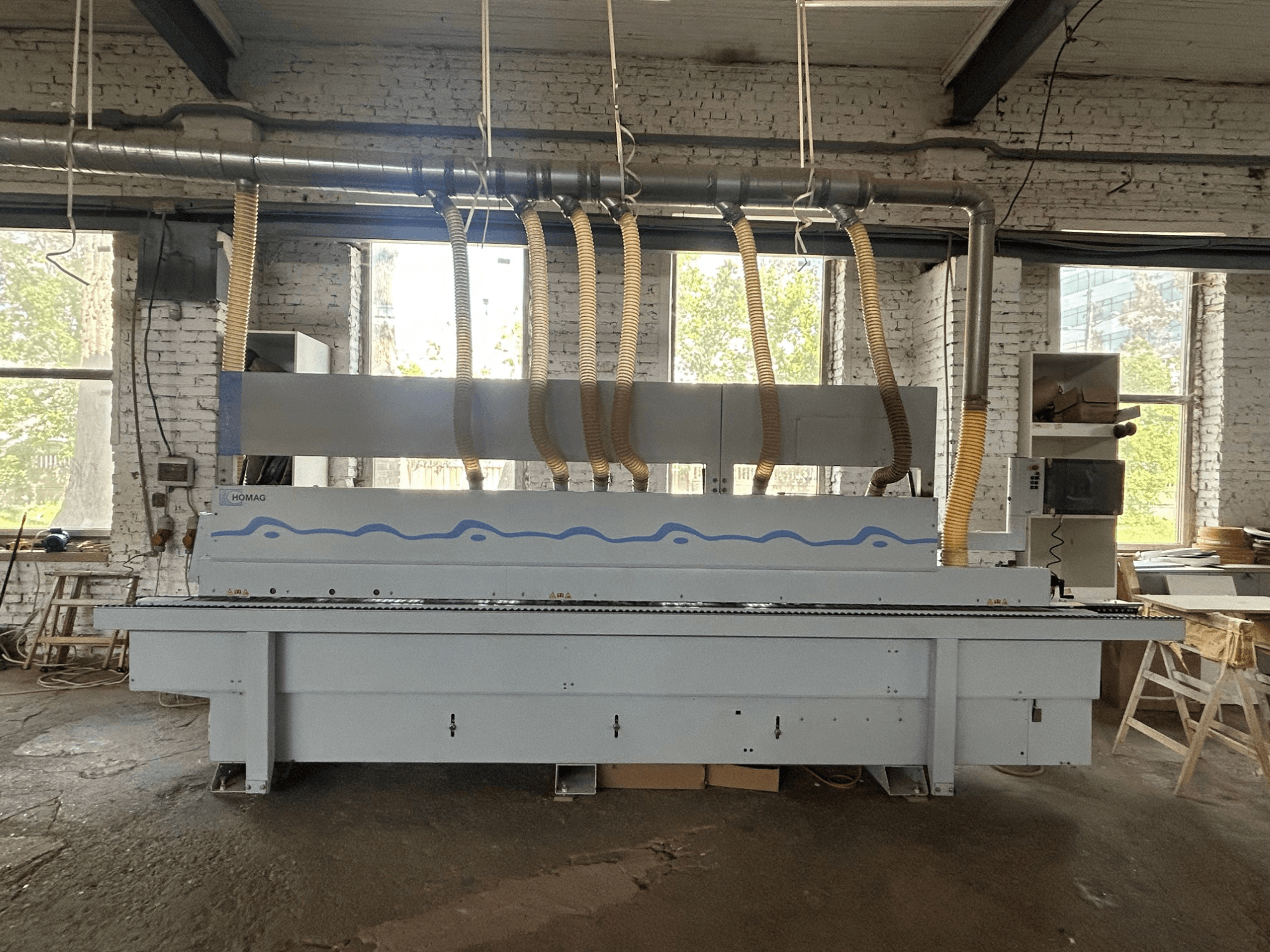 Front view of HOMAG Optimat KDF 440 C edgebander, showcasing a large machine with dust extraction hoses and a control panel.
