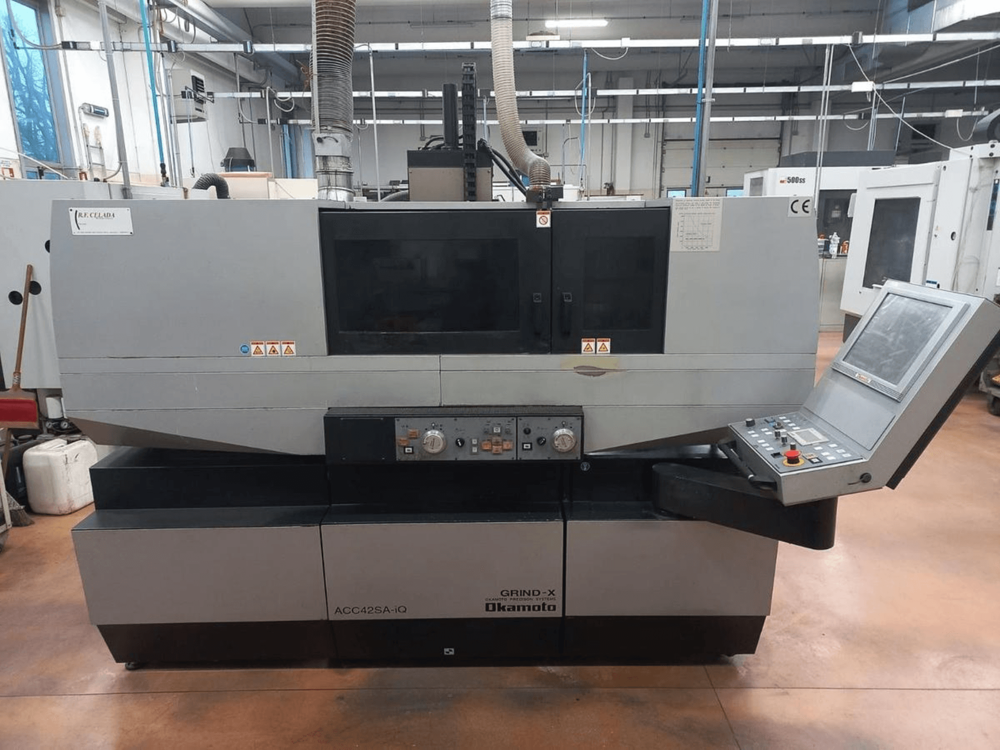 Front view of the OKAMOTO ACC 42 SA-iQ surface grinding machine, showcasing control panel and safety indicators.