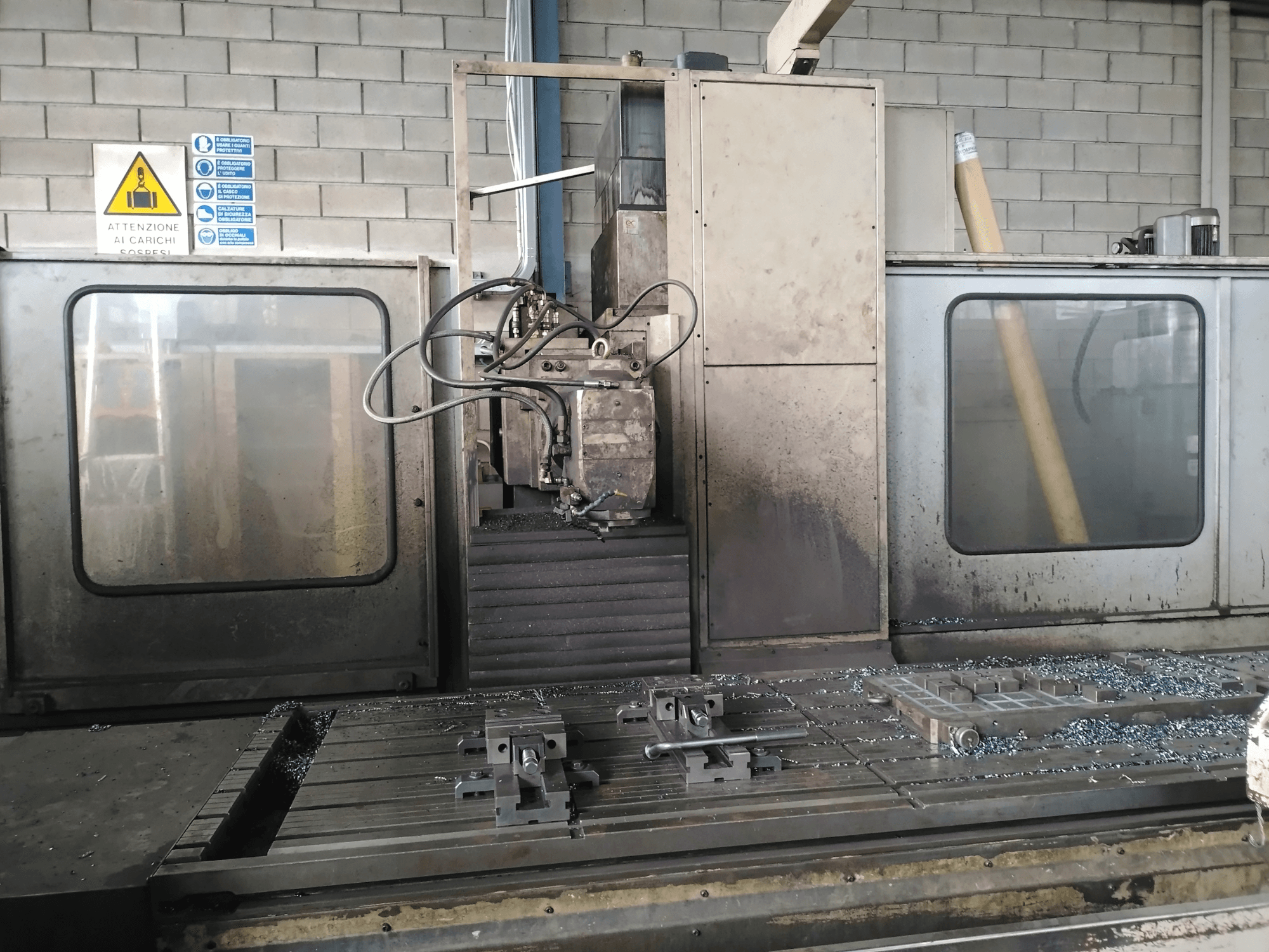TIGER TFA6 bed type milling machine in a workshop, front view showing tools and metal shavings on the table.
