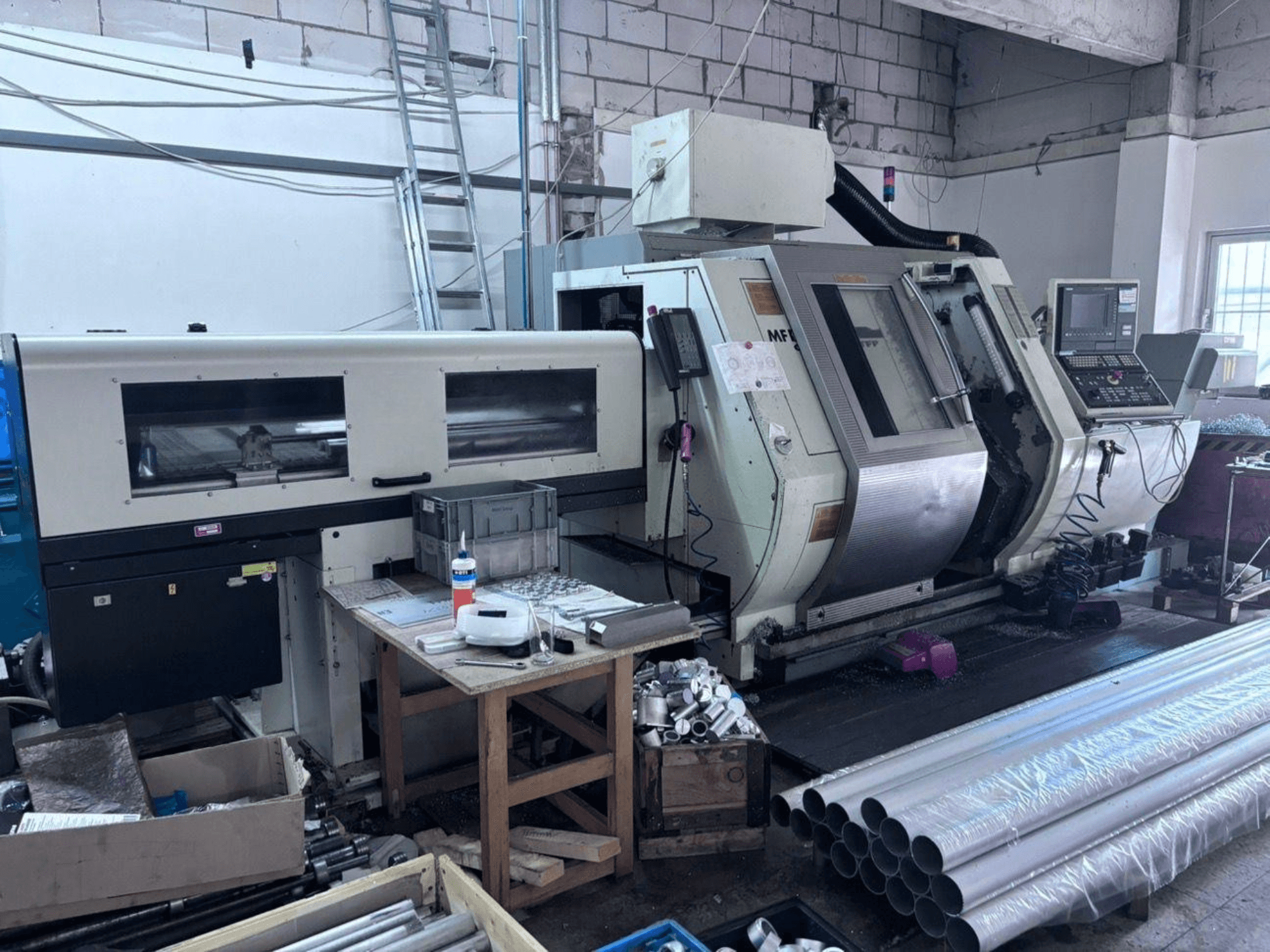 Gildemeister MF Twin 65 Turn-Mill Centre, side view showing control panel, machining area, and aluminum pipes.