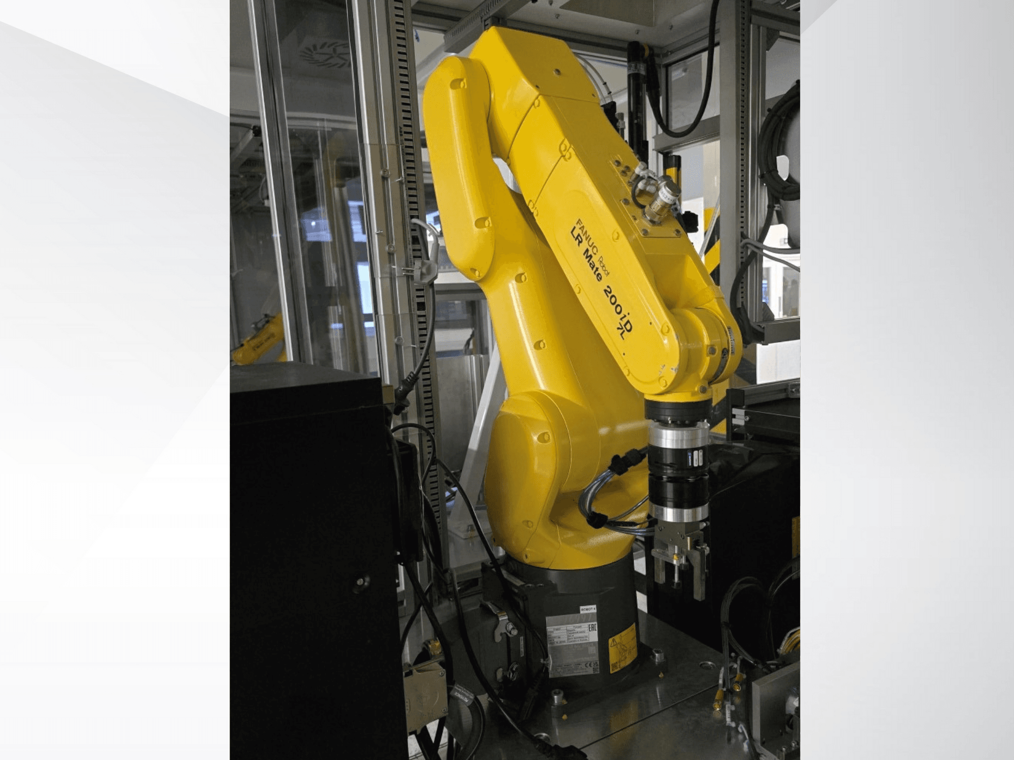 Yellow Fanuc LR Mate 200iD robotic arm shown from a side view, featuring a gripper and various cables attached.