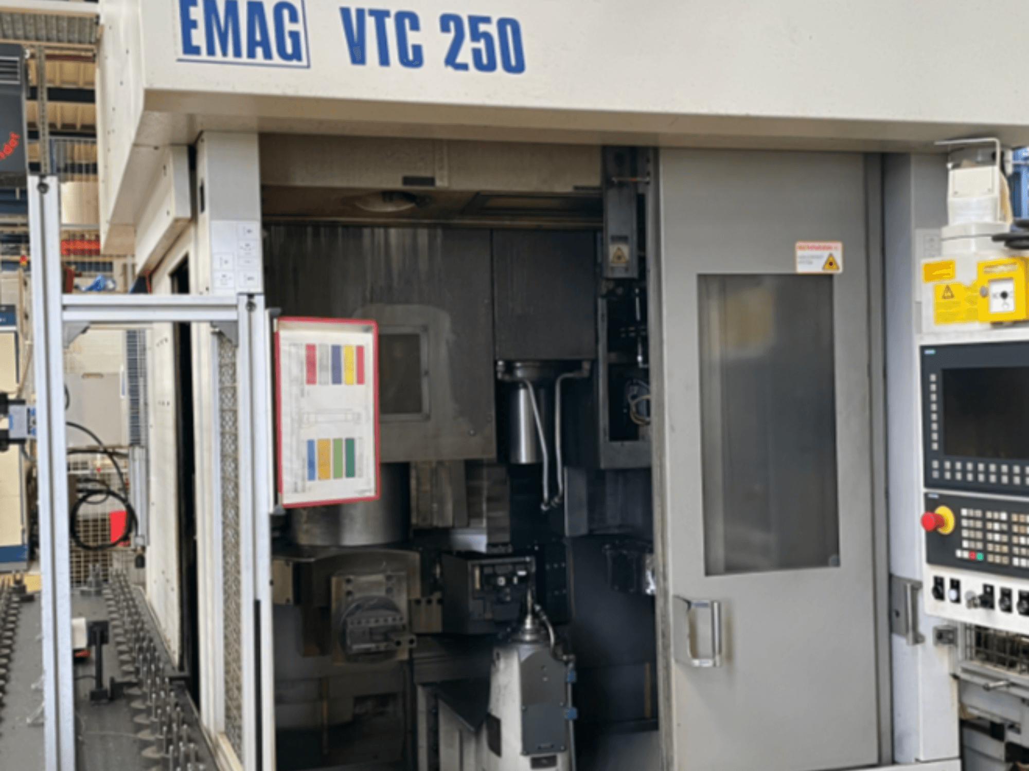 Front view of EMAG VTC 250 vertical turning machine, showing control panel, operational interface, and open access door.