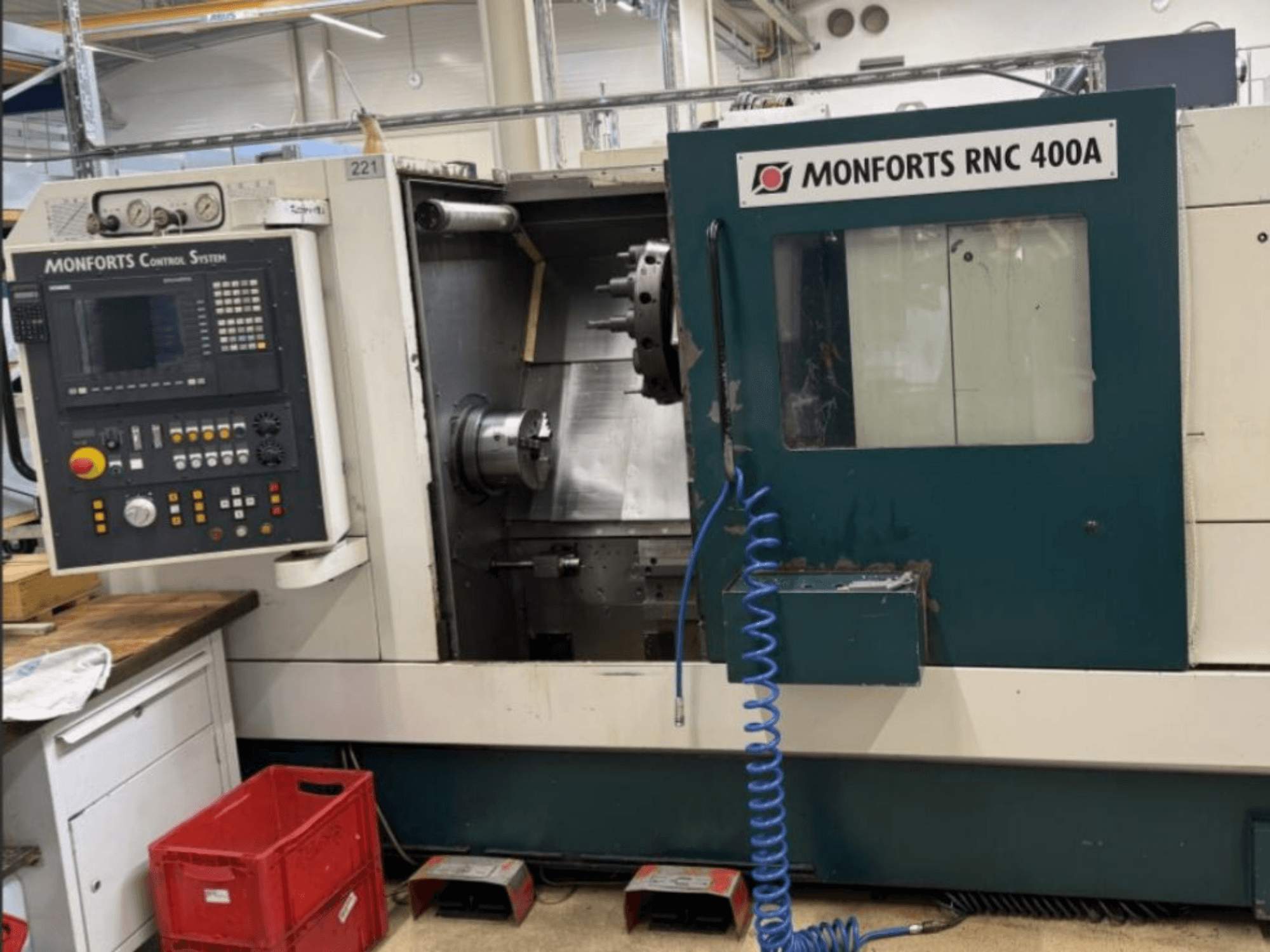 Monforts RNC 400 A horizontal turning machine, front view, showcasing control panel and work area with highlighted features.