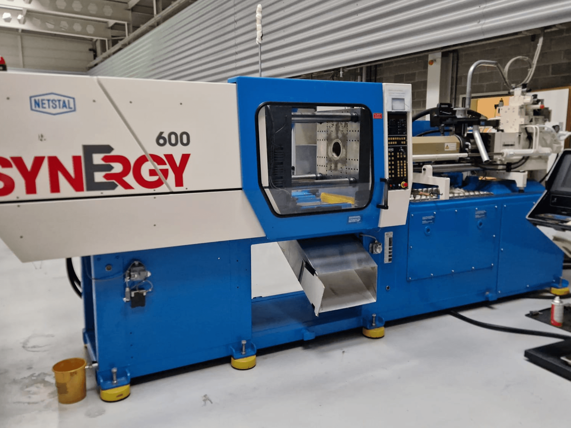 Netstal Synergy 600-230 hydraulic injection moulding machine, side view showing control panel and injection area.