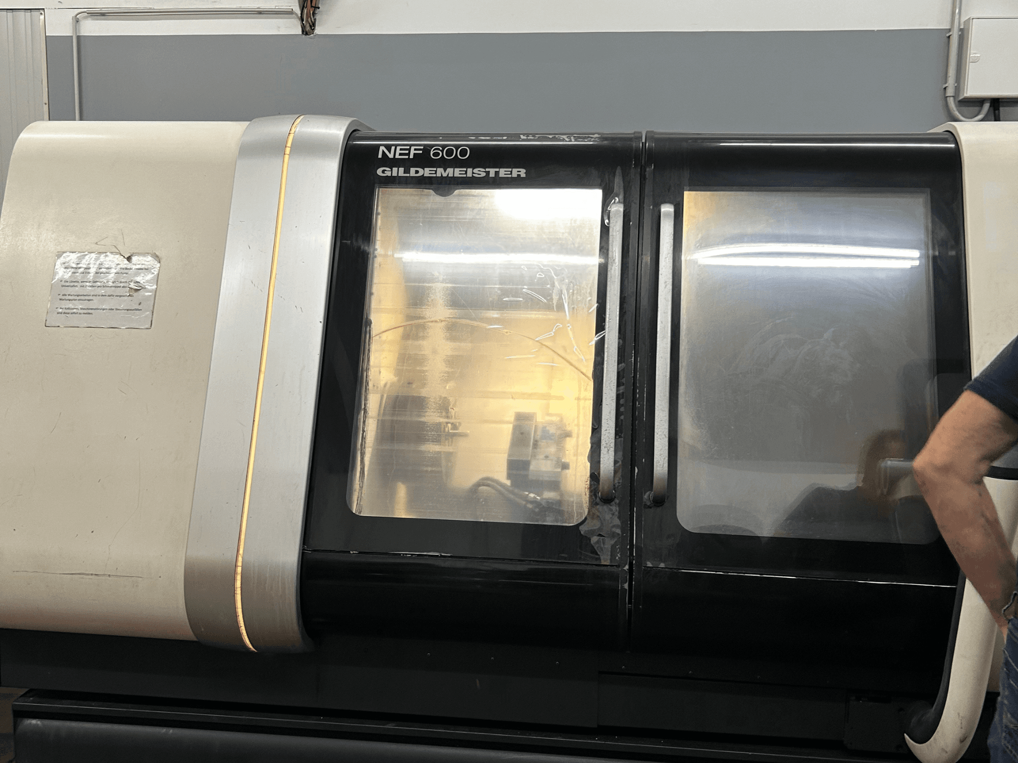 Horizontal turning machine DMG NEF 600, front view, featuring a glossy finish and large viewing windows.