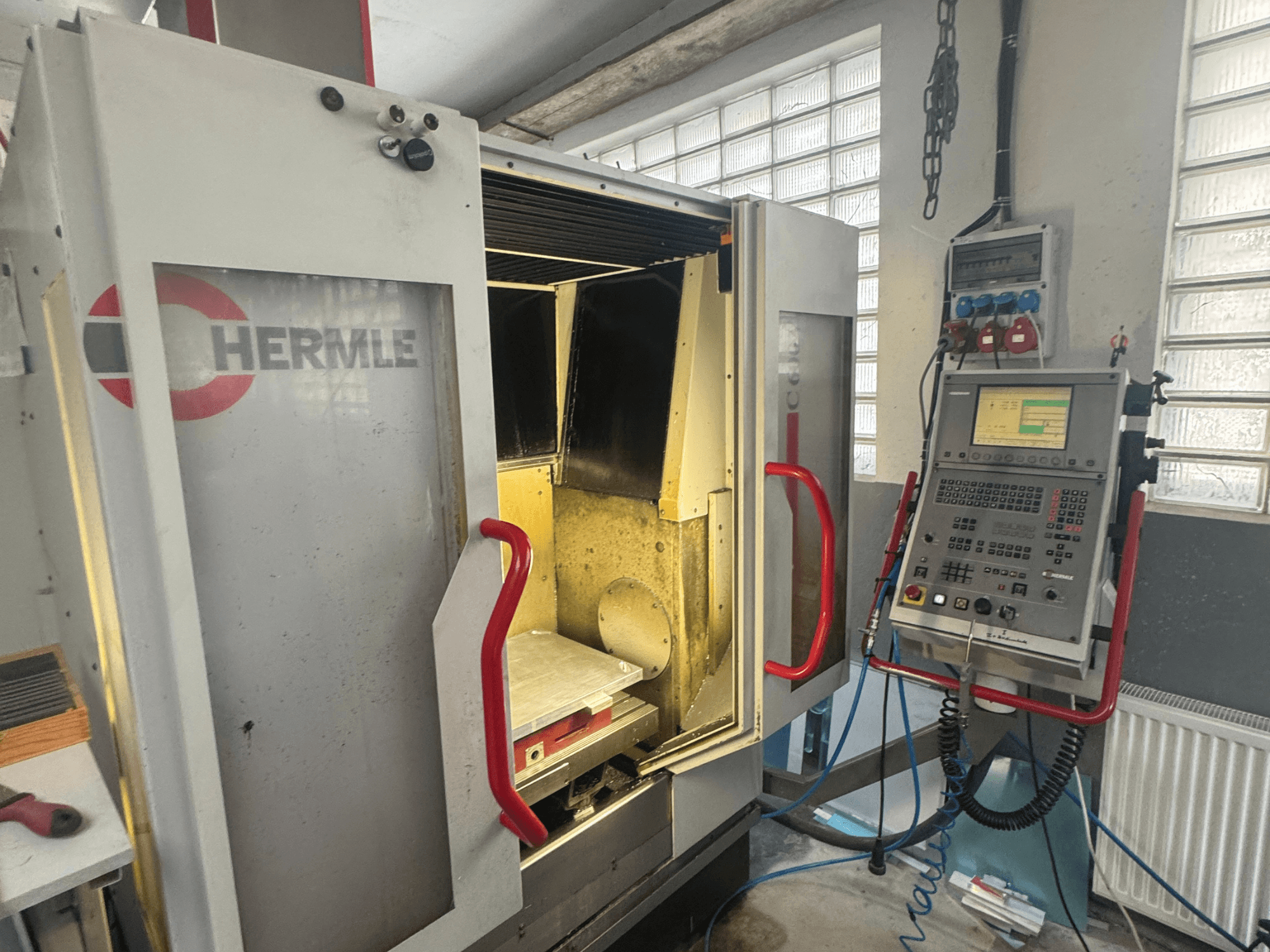 HERMLE C600V vertical machining centre, front view showing open door, control panel, and interior work area.