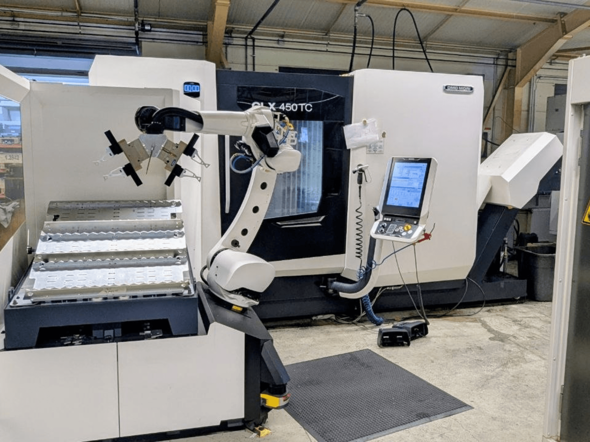DMG MORI CLX 450 TC with Robo2go, front view, showcasing robotic arm and control panel beside the machine.