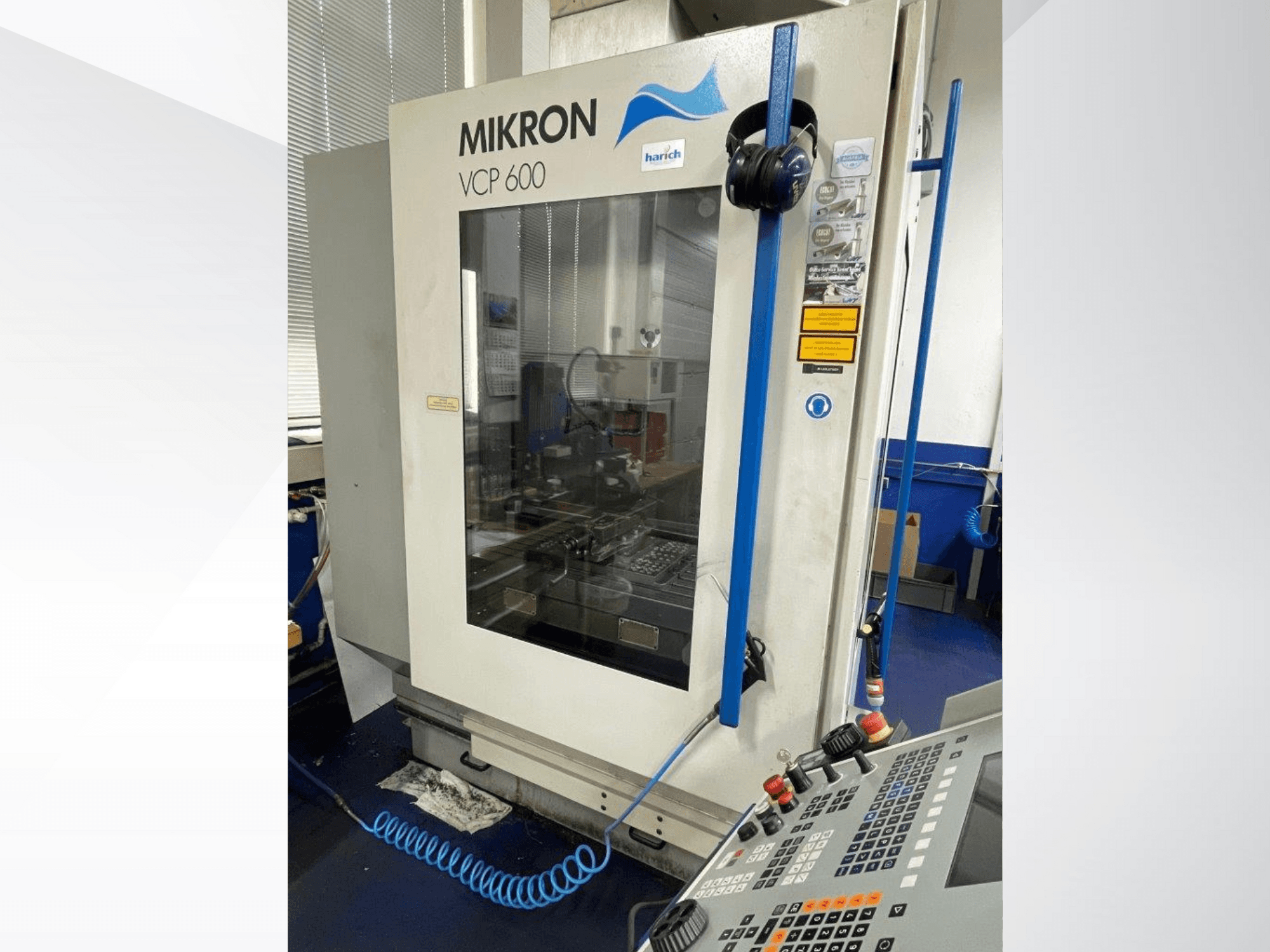 Mikron VCP 600 CNC machine, front view, features control panel with buttons, and visible machining area behind glass.
