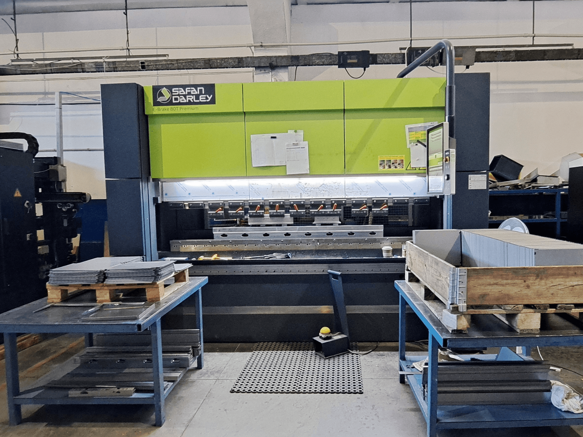 SAFAN E-Brake Premium 80-2550 press brake in a workshop, front view with stacked metal sheets and a control panel visible.