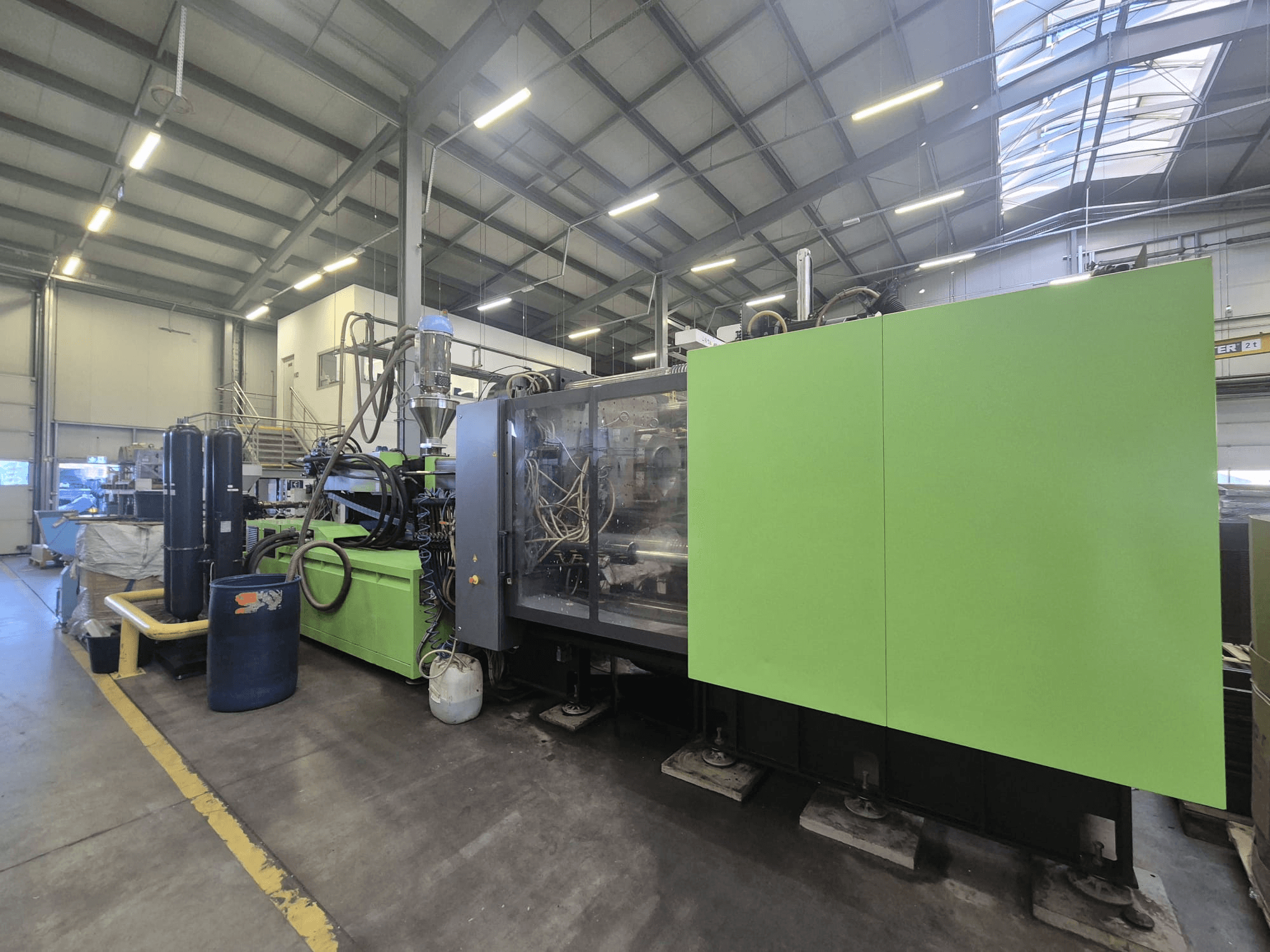 Engel duo 5160/700 hydraulic injection moulding machine in a factory setting, viewed from the side, showcasing its green exterior and components.