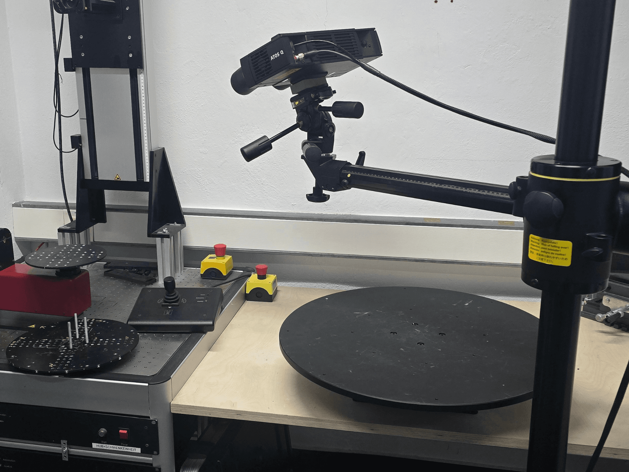 Front view of ZEISS ATOS Q 12M optical measurement machine, featuring a scanning head, control panel, and rotating circular platform.