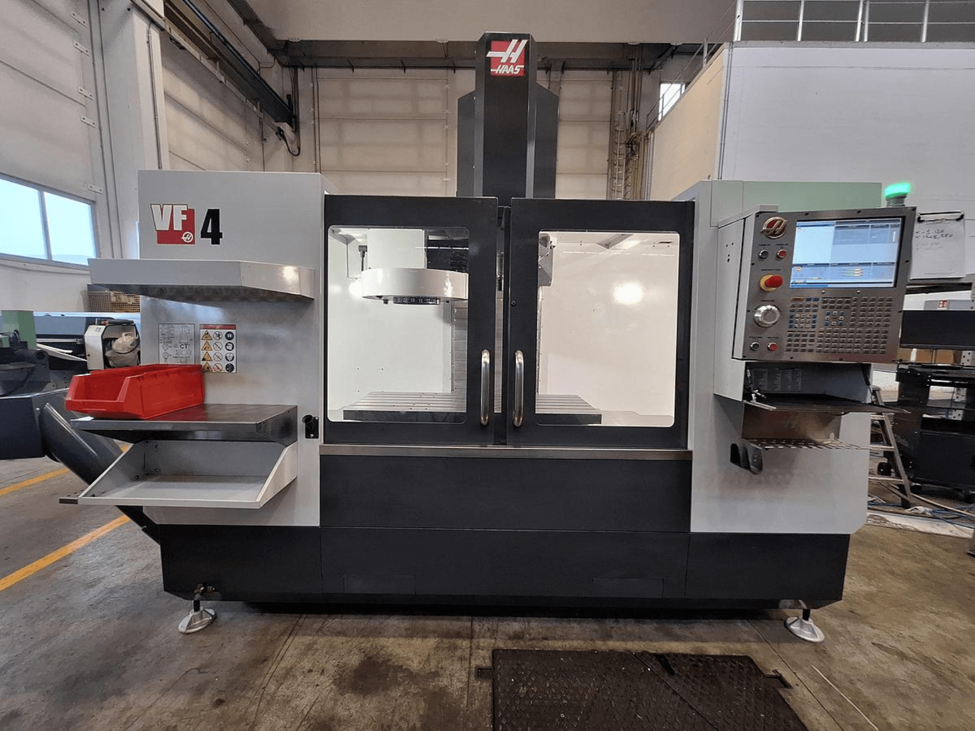 Haas VF-4 vertical machining center, front view, featuring a control panel, tool holder, and spacious work area.