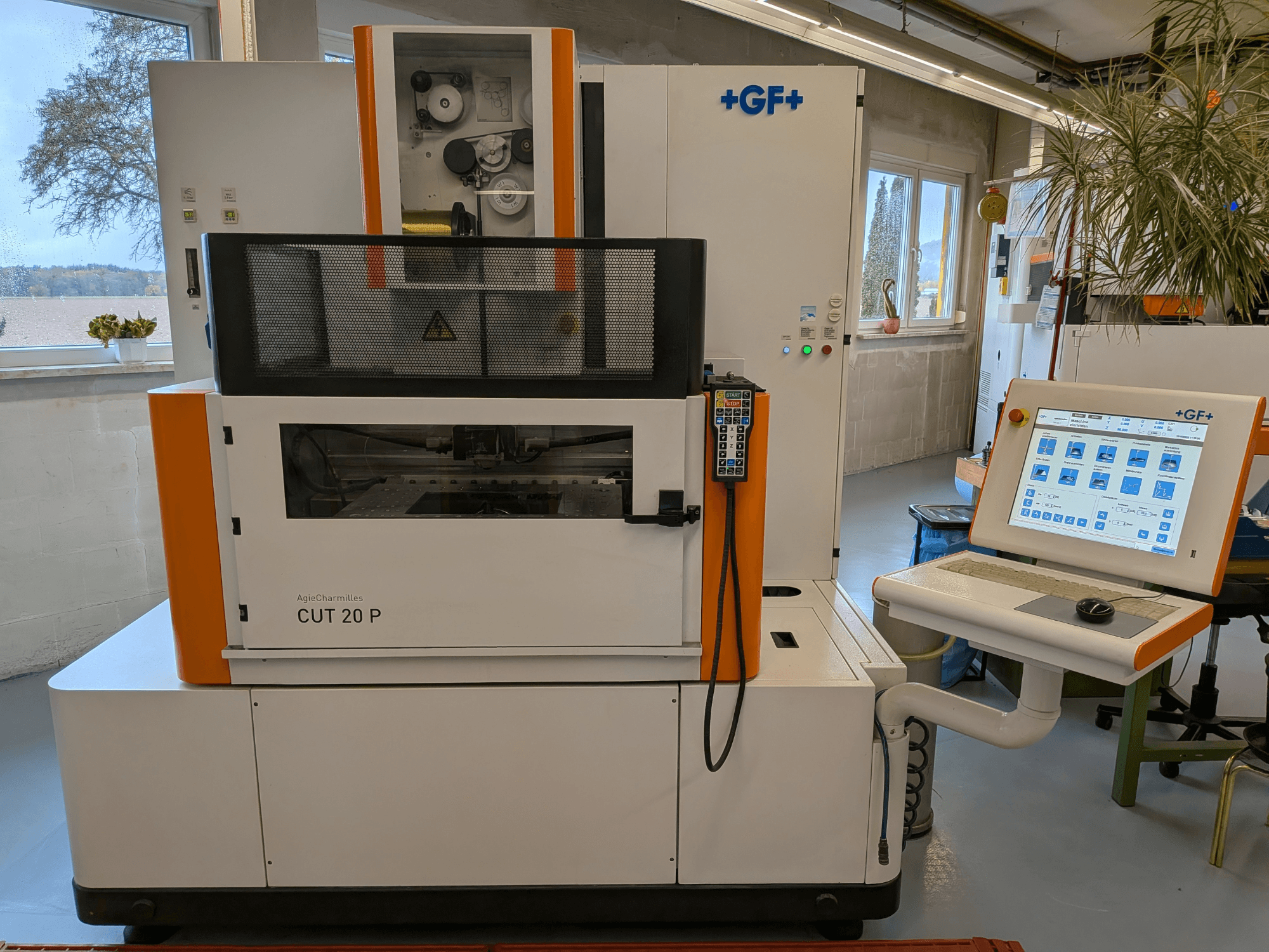AgieCharmilles Cut-20 P wire EDM machine in front view with control panel and display, set in a well-lit workshop.