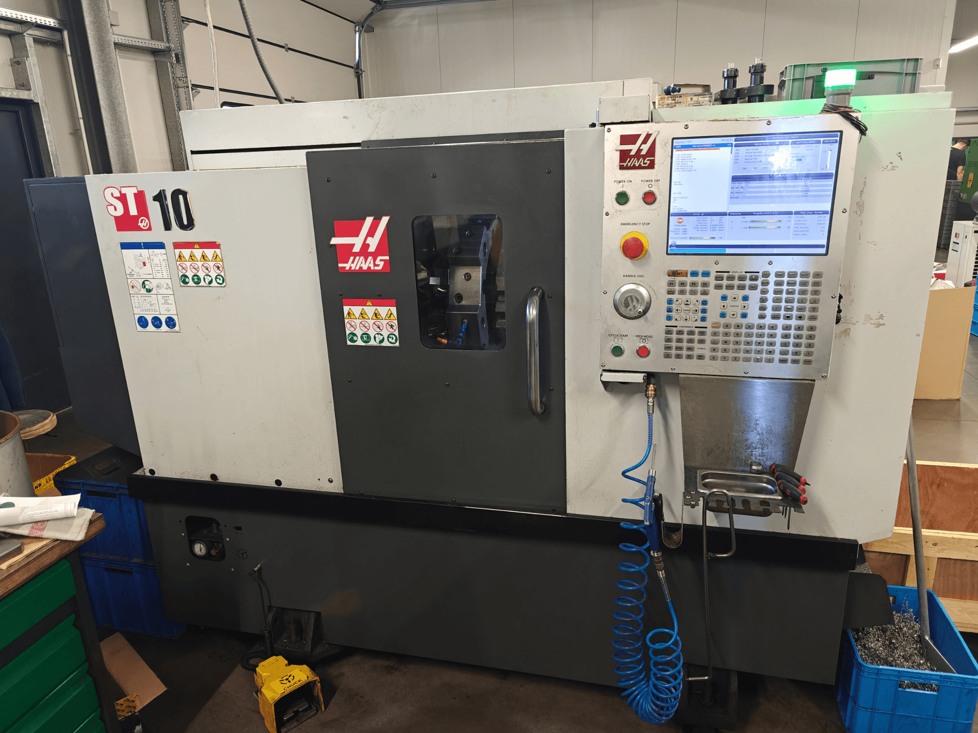 Haas ST-10 horizontal turning machine, front view, showcasing control panel, safety labels, and machine structure.