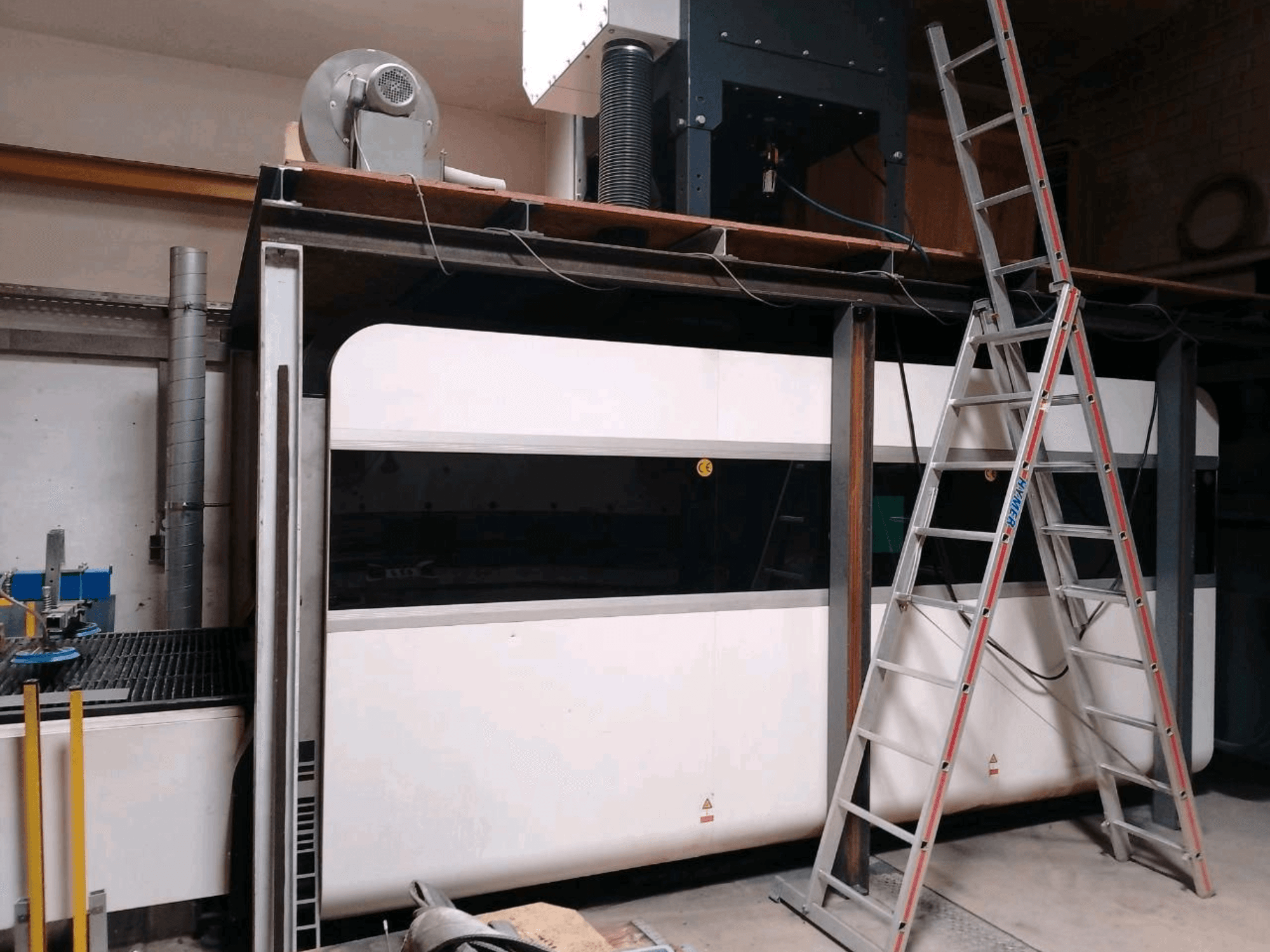 GWEIKE LF3015GA fiber laser cutting machine in a workshop, showing front view, metal frame, and access ladder.