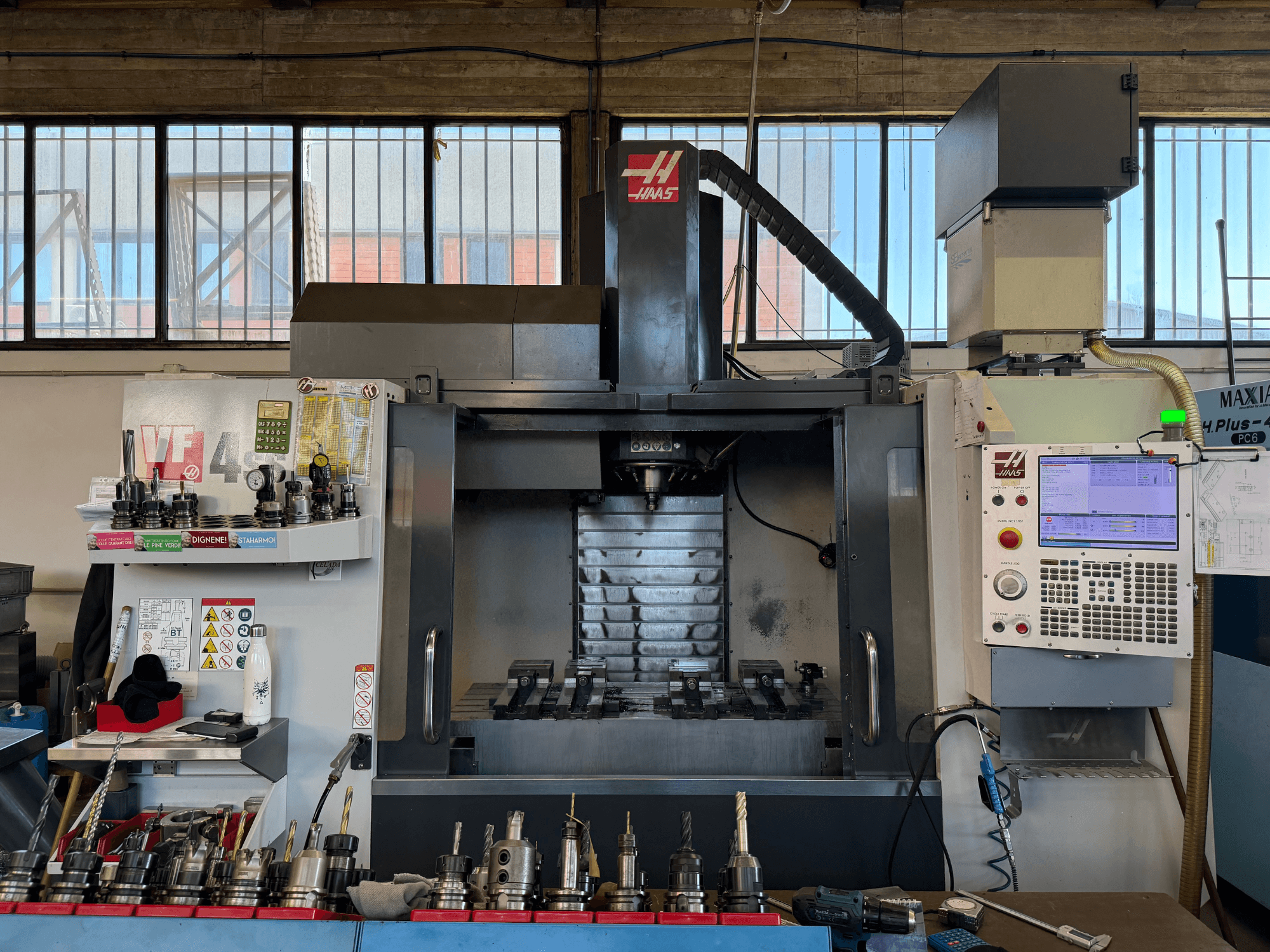 HAAS VF-4SS vertical machining center, front view, featuring control panel, tool holders, and visible spindle area.