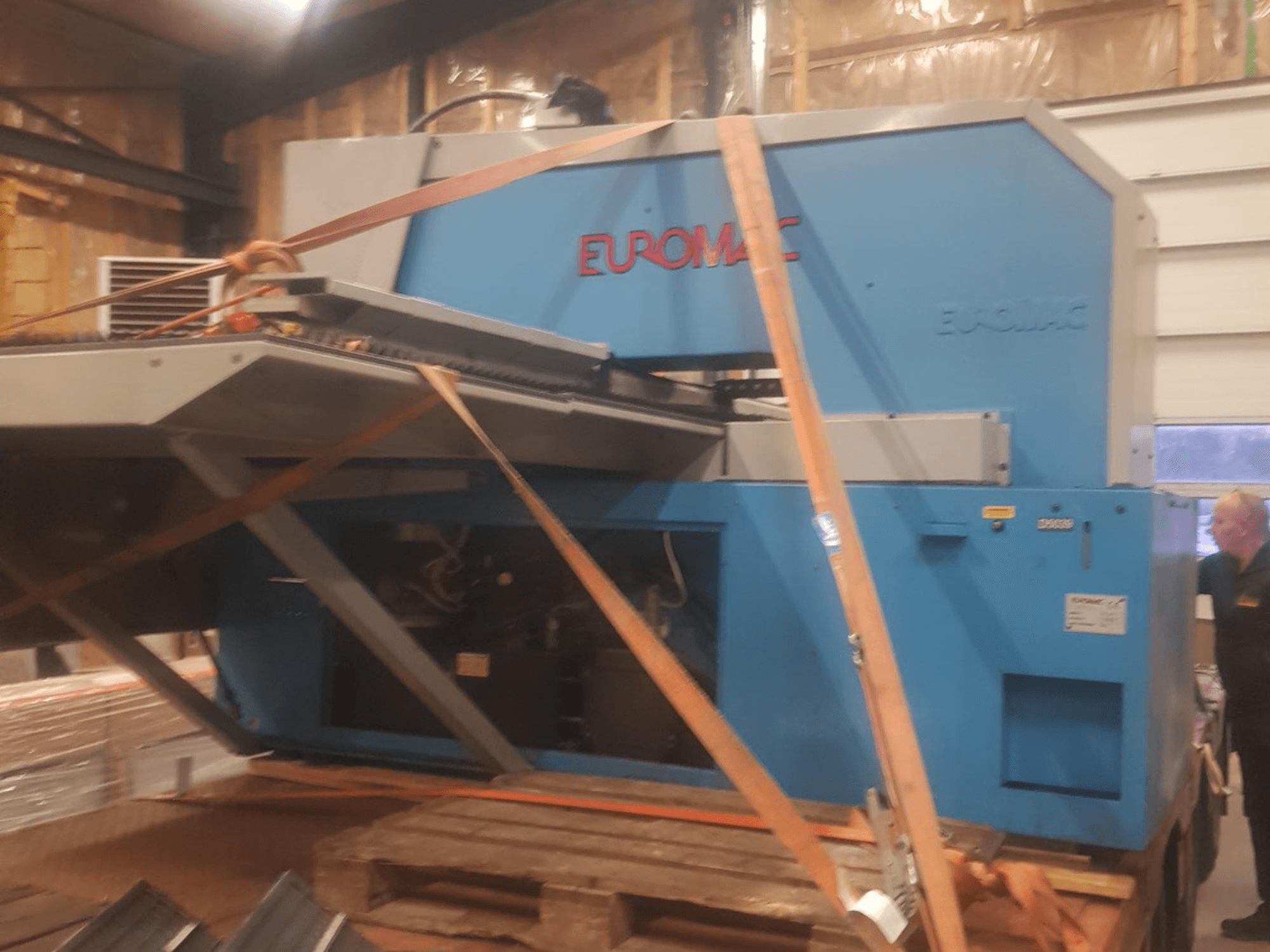CNC punching machine Euromac ZX INDEX viewed from the side, secured with straps, showcasing a blue metallic finish.