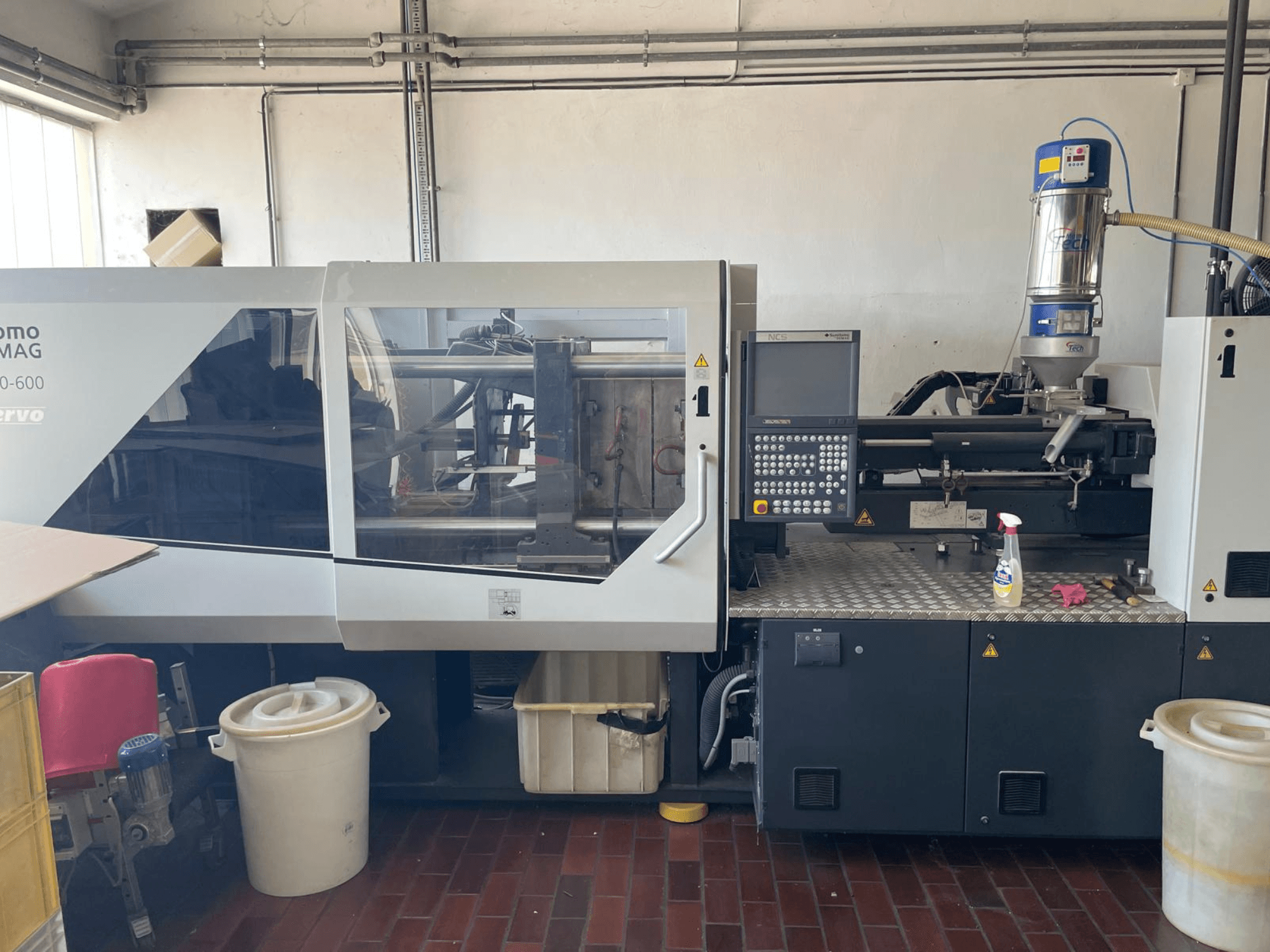 Front view of SUMITOMO SHI DEMAG Systec 160/520-600 hydraulic injection molding machine with control panel and feeding unit.