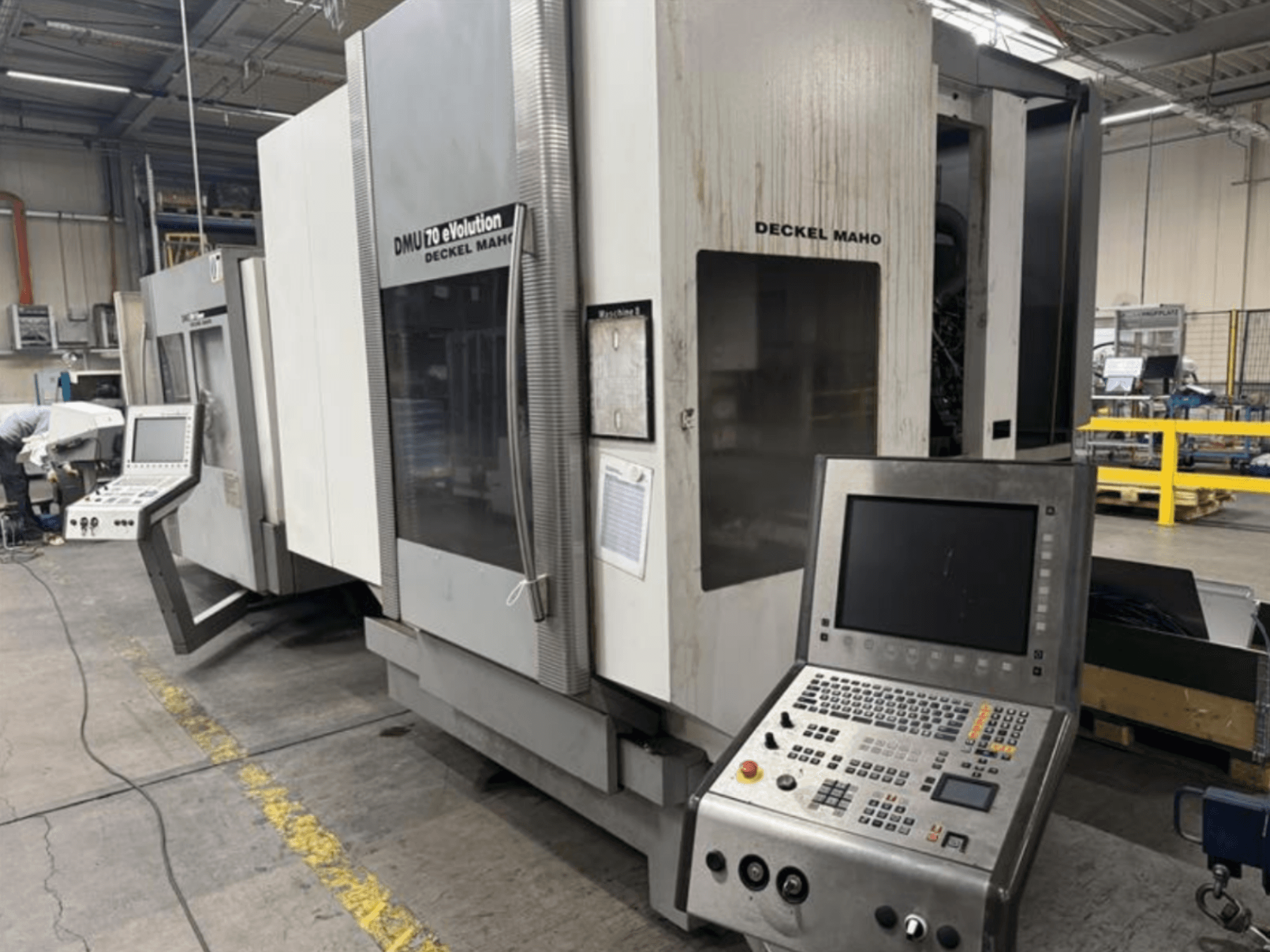 Front view of a Deckel Maho DMU 70 eVOLUTION CNC machine with control panel, located in a manufacturing facility.