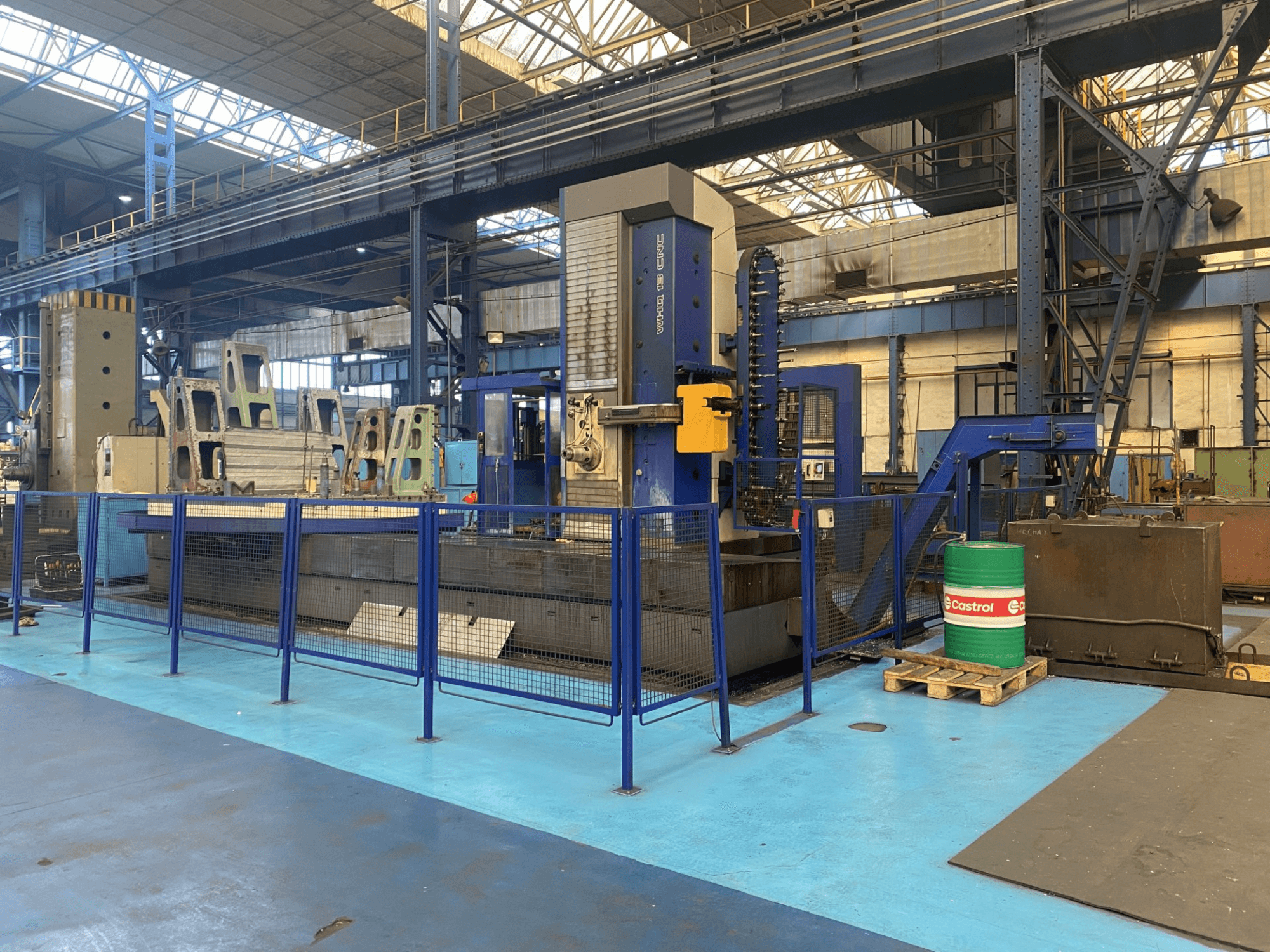 TOS WHQ 13 CNC boring machine in a workshop, front view, showing blue frame and surrounding safety fence.