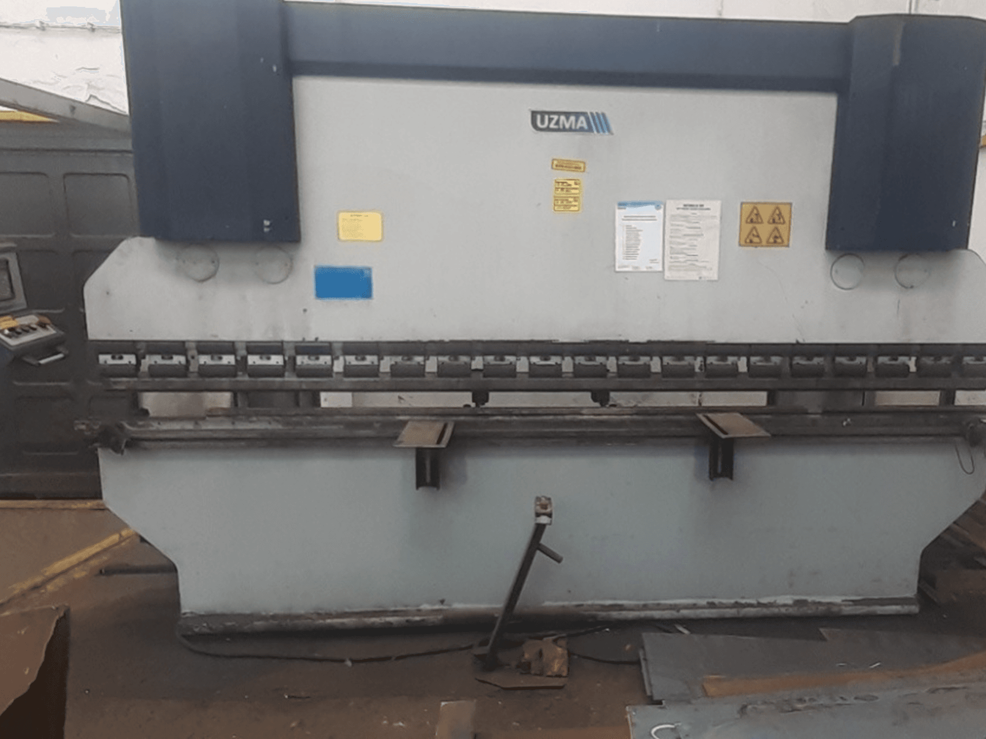 UZMA HAP 40160 press brake in front view, featuring controls, safety warnings, and metal bending tools.