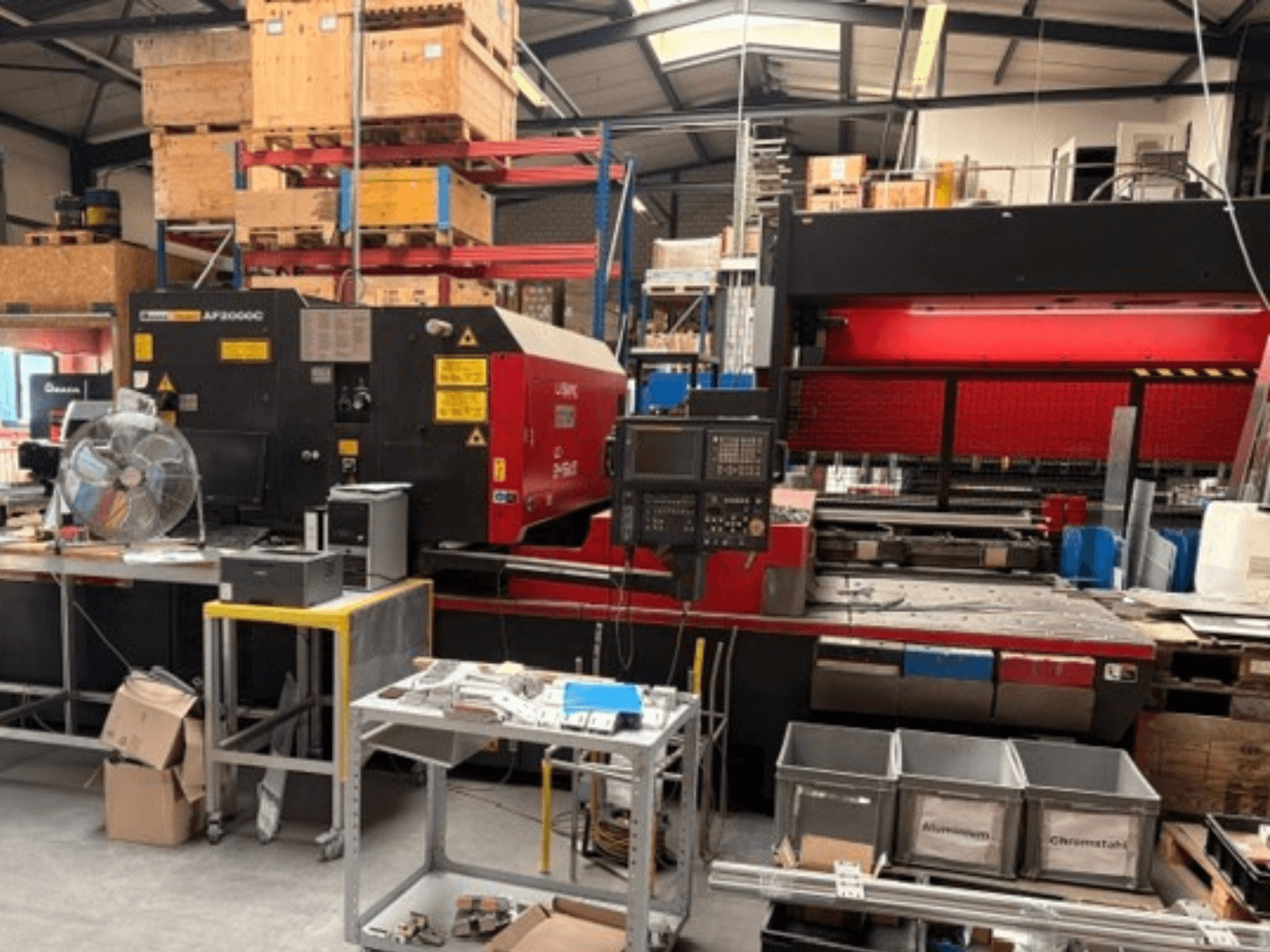 AMADA LC-2415αIII CO2 Laser Cutting Machine in a workshop setting, showing front view, control panel, and operational space.